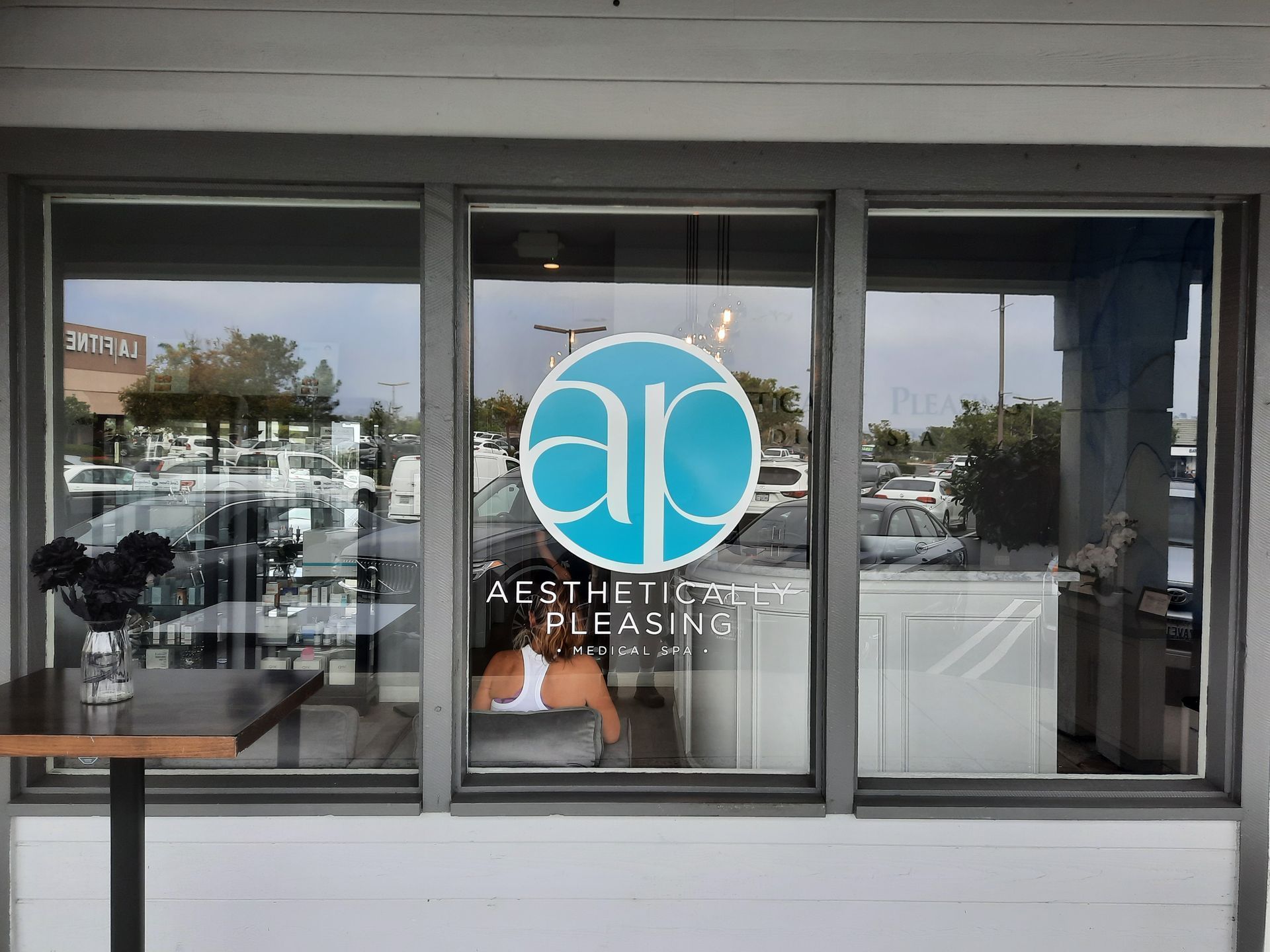 Aesthetic Plastic Surgery clinic storefront with glass doors and blue circular logo