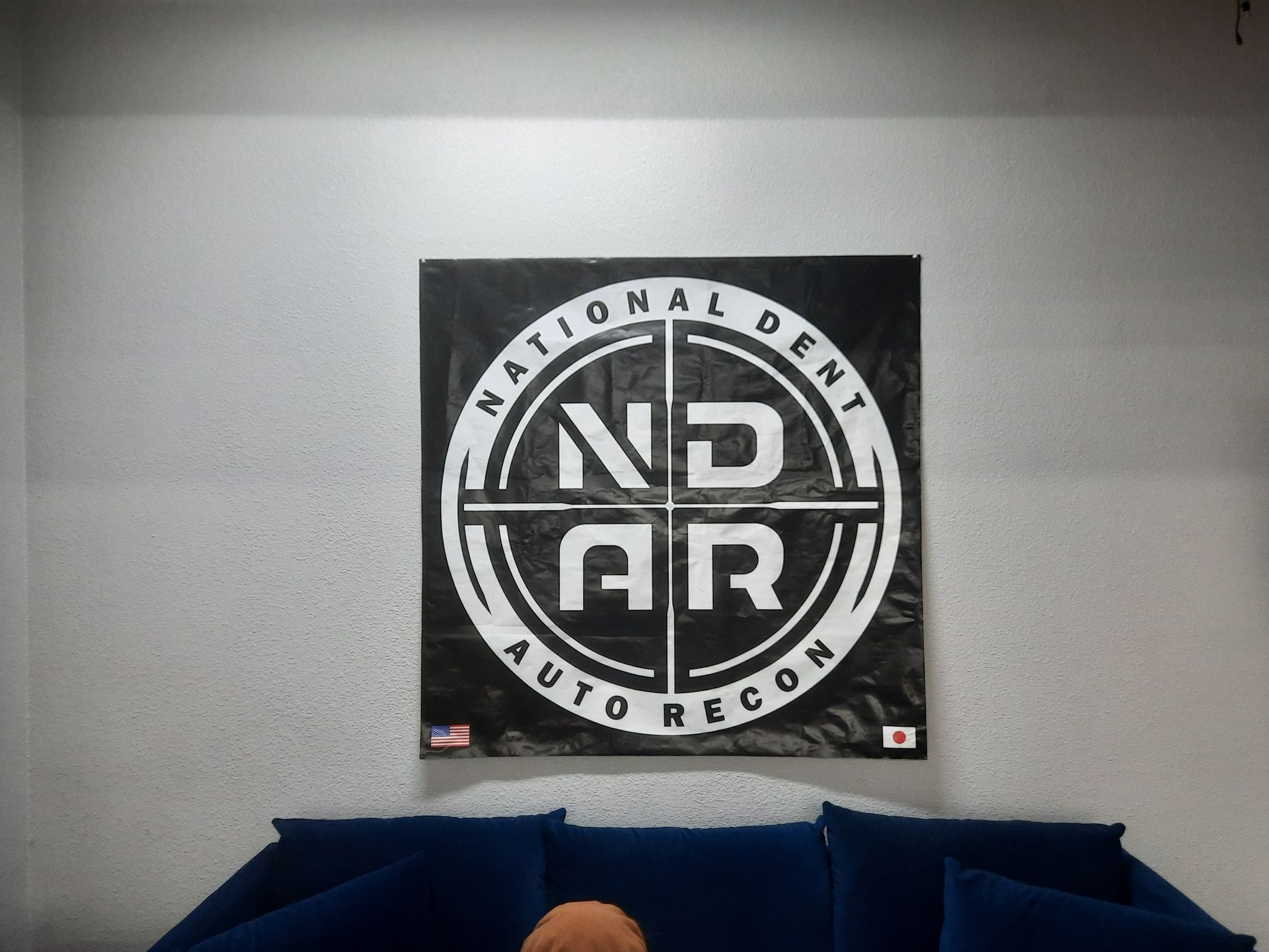 National Dent Auto Recon logo on a wall above dark blue couches in a waiting area