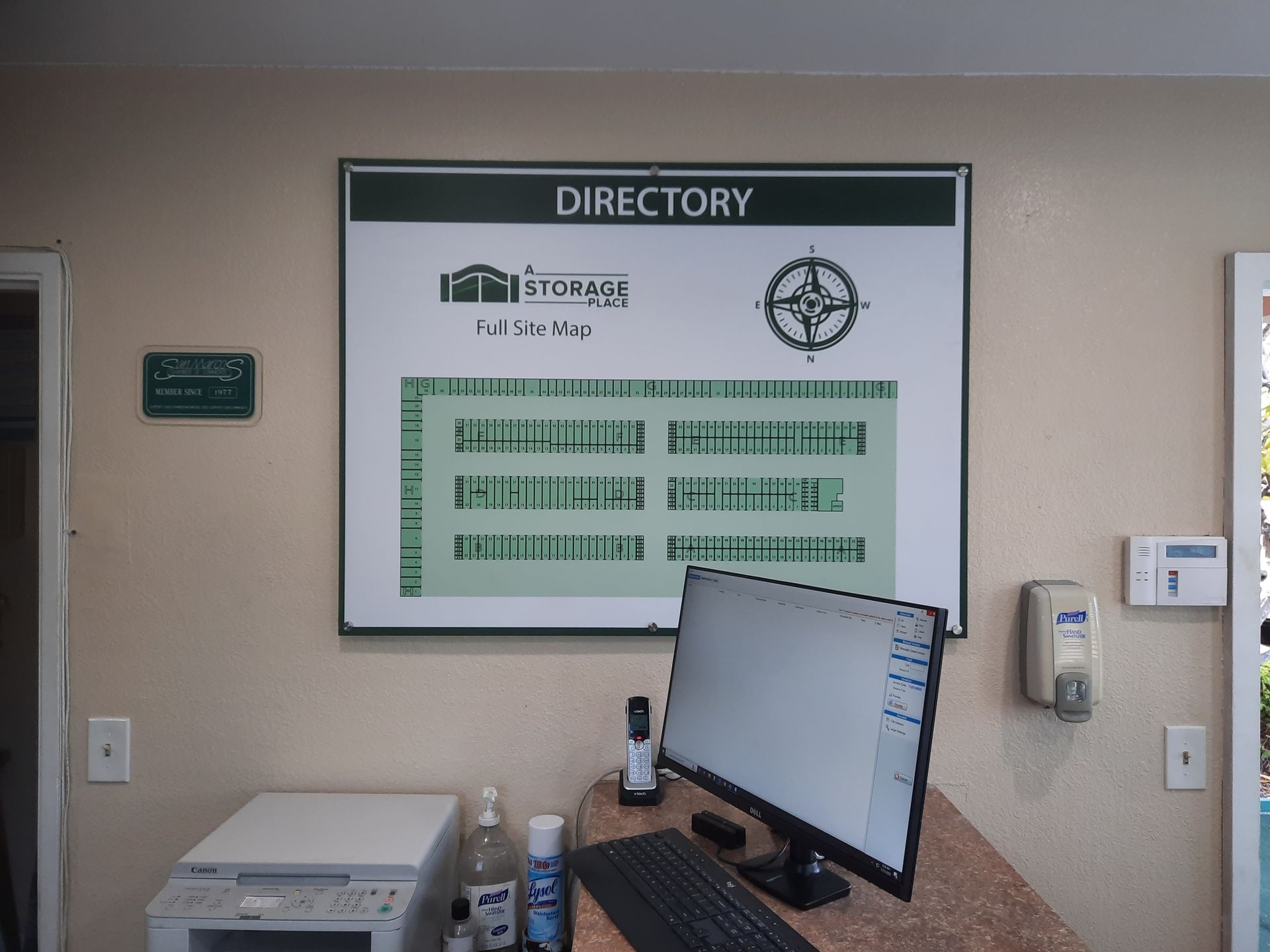 Hospital directory sign above a desk with a computer monitor in a beige hallway
