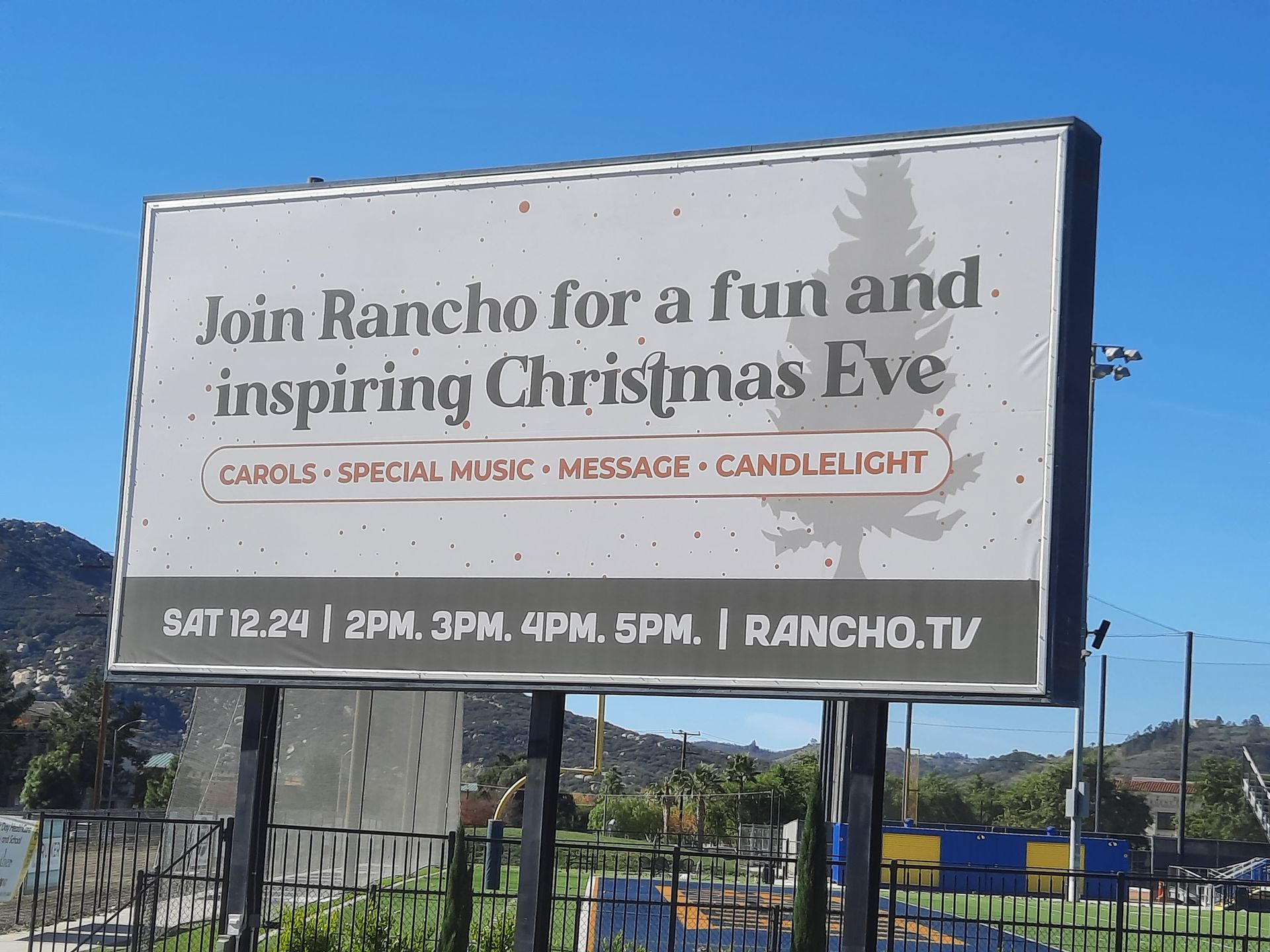 Billboard for Rancho’s Christmas Eve event against a mountain backdrop