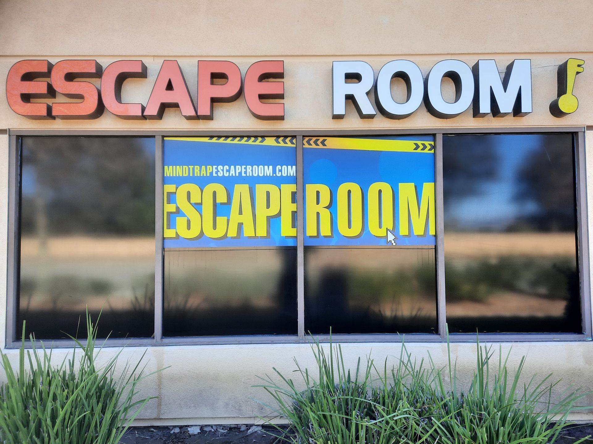 Escape Room storefront with large red and white sign and blue window lettering.