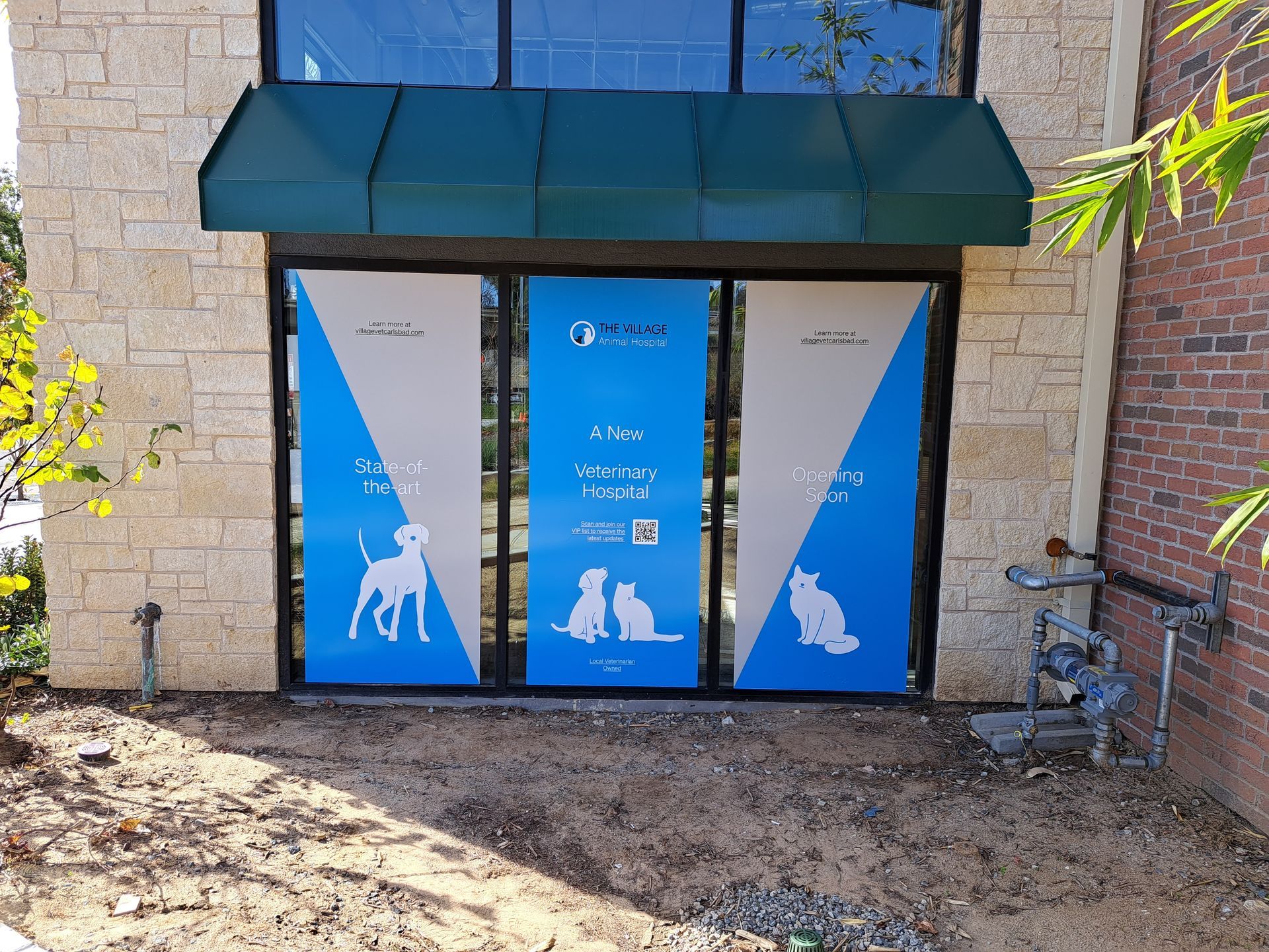 Blue storefront entrance with a green awning and white animal graphics on the doors