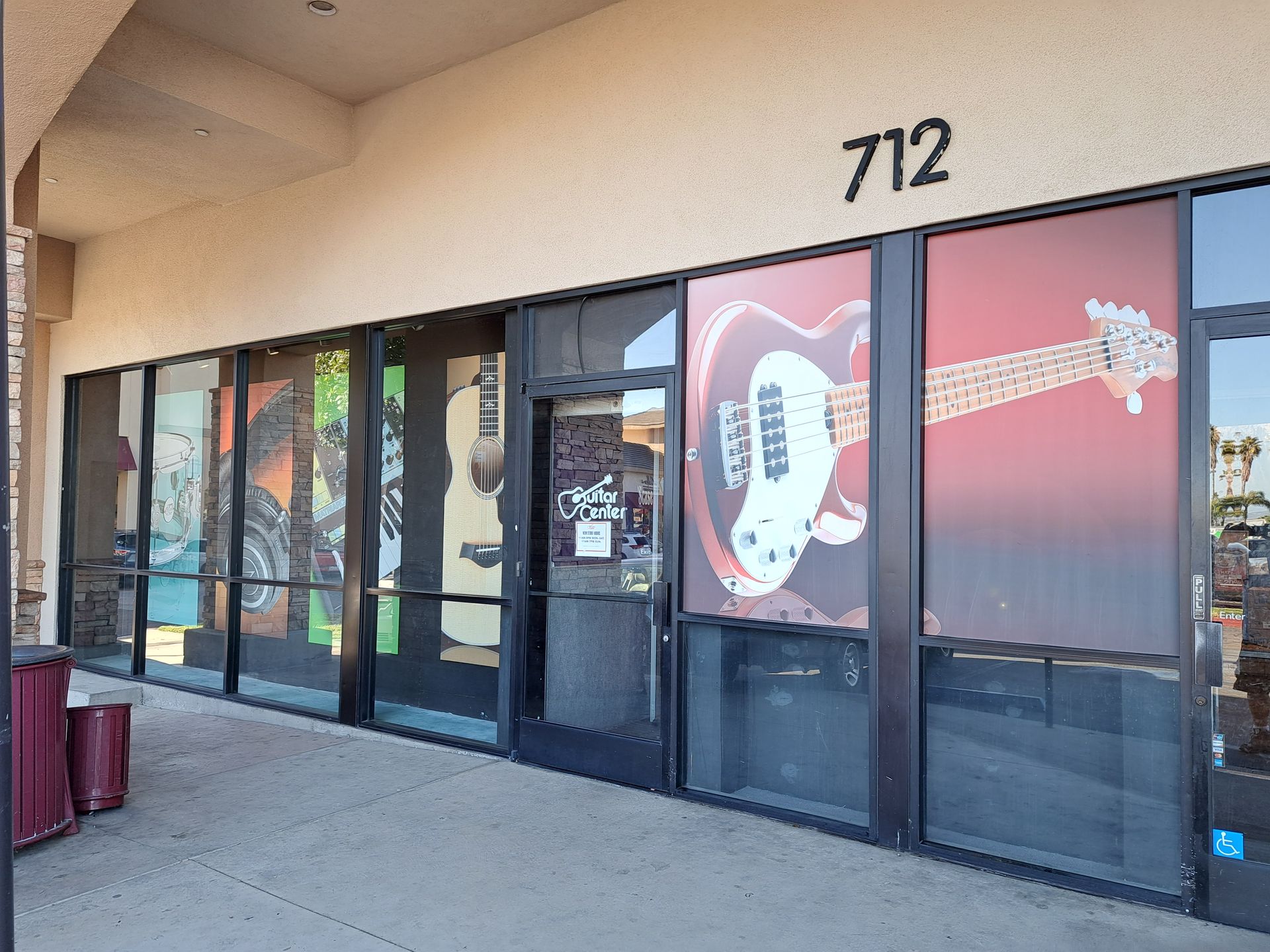 Storefront entrance with glass doors and red window graphics, numbered 712