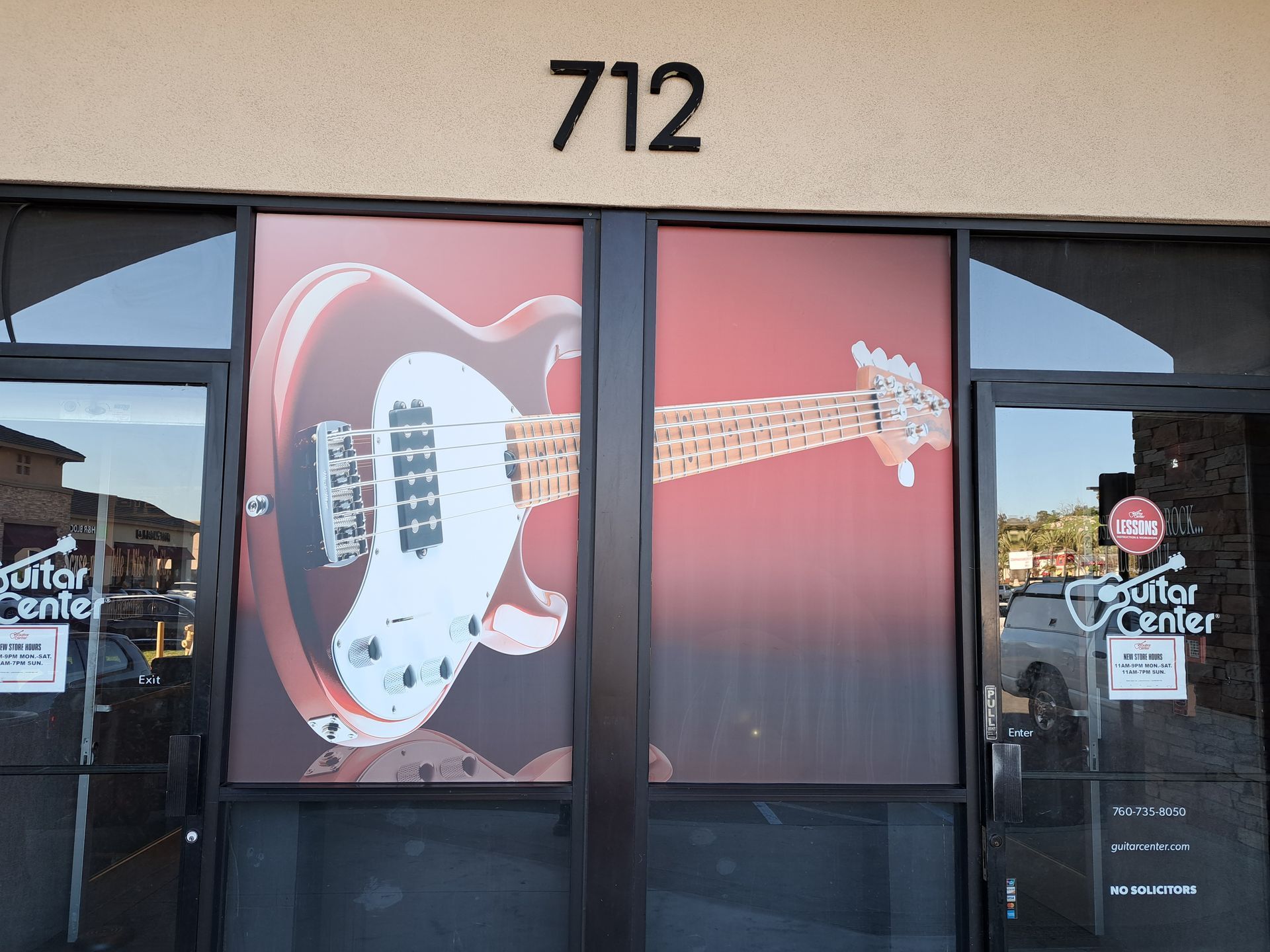 Storefront with a large guitar mural and the number 712 above the door.