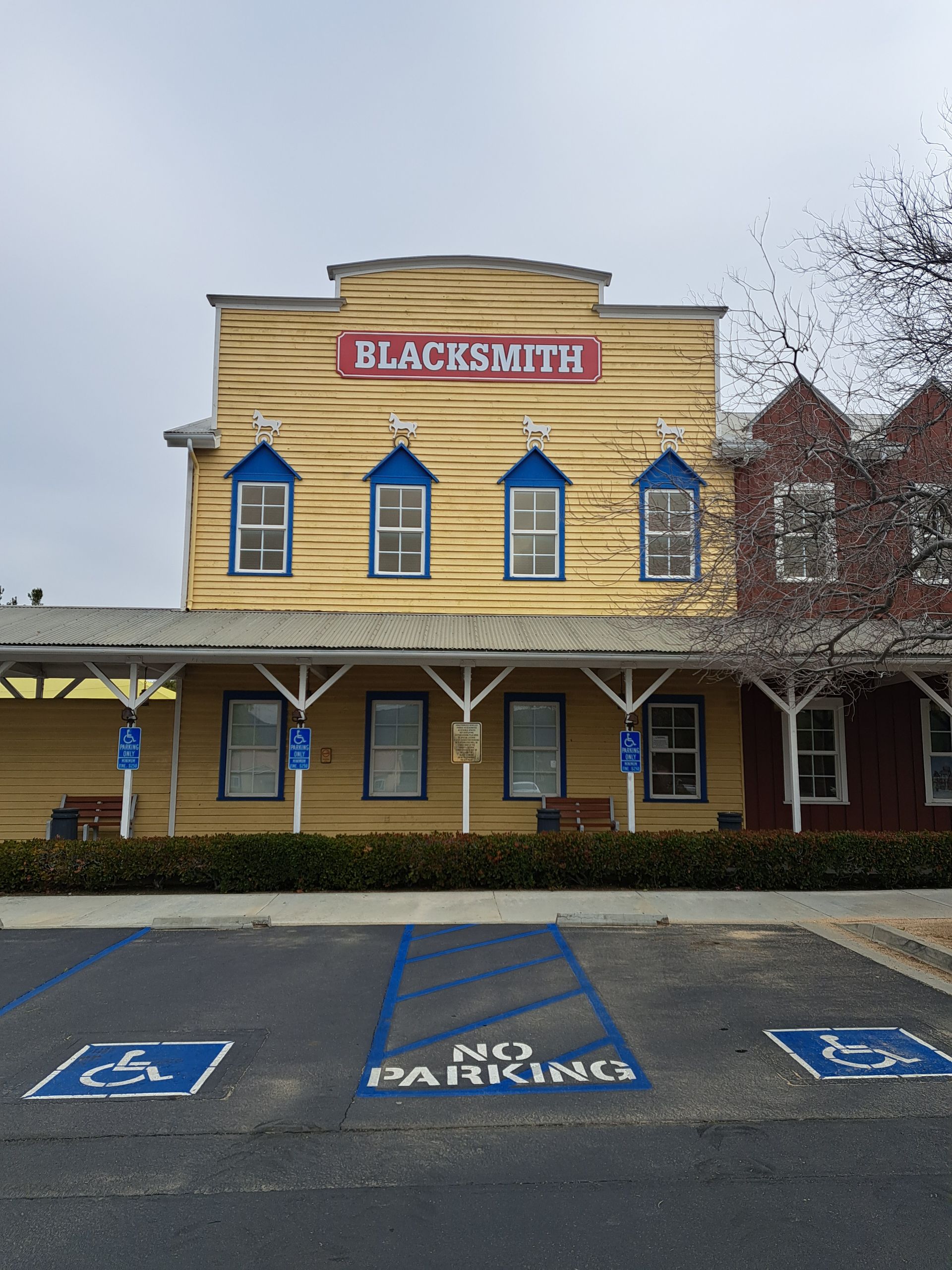 Blacksmith building facade with blue handicap parking spaces in front