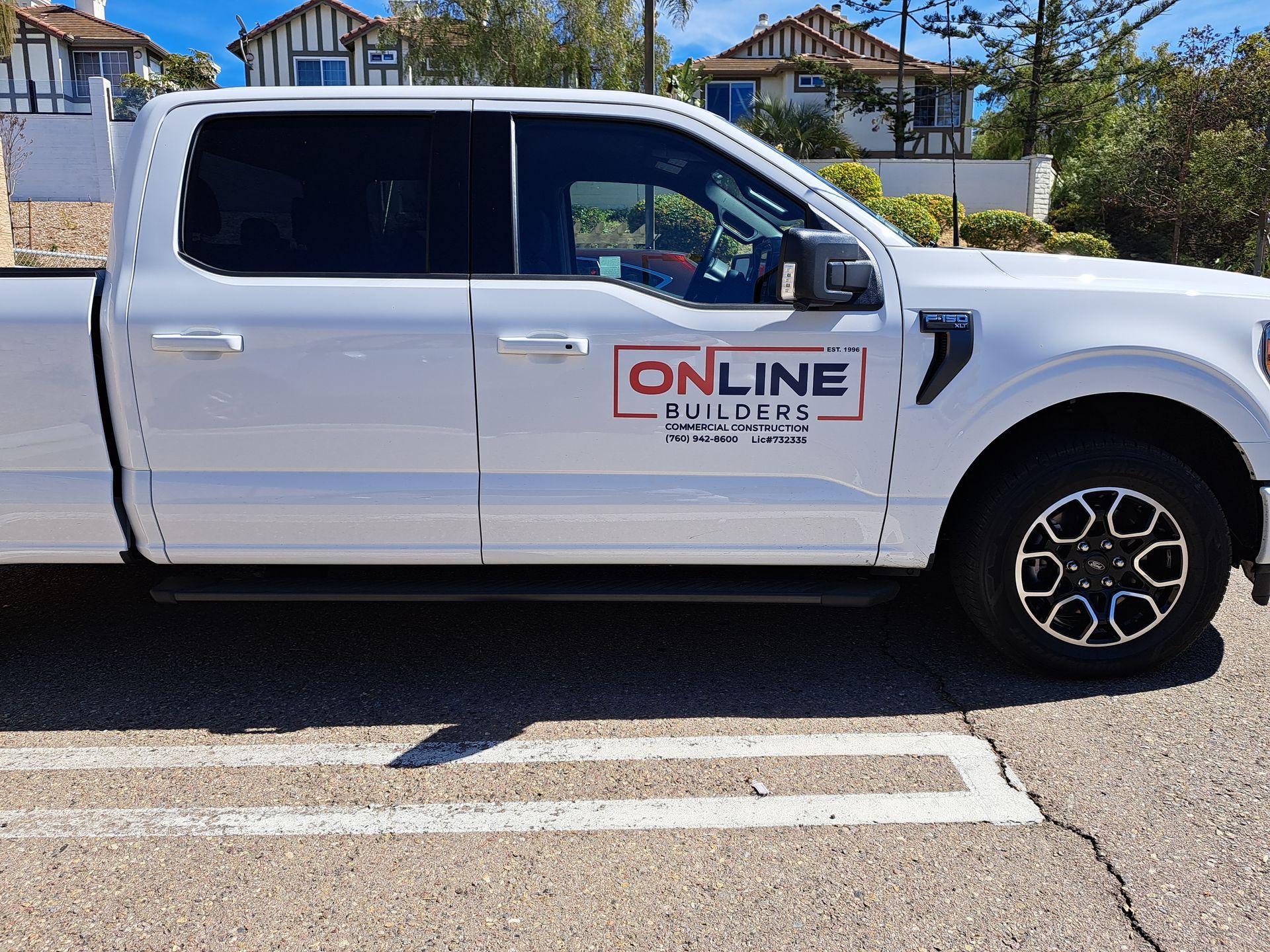 White pickup truck with “ONLINE” logo parked on a street in a residential area