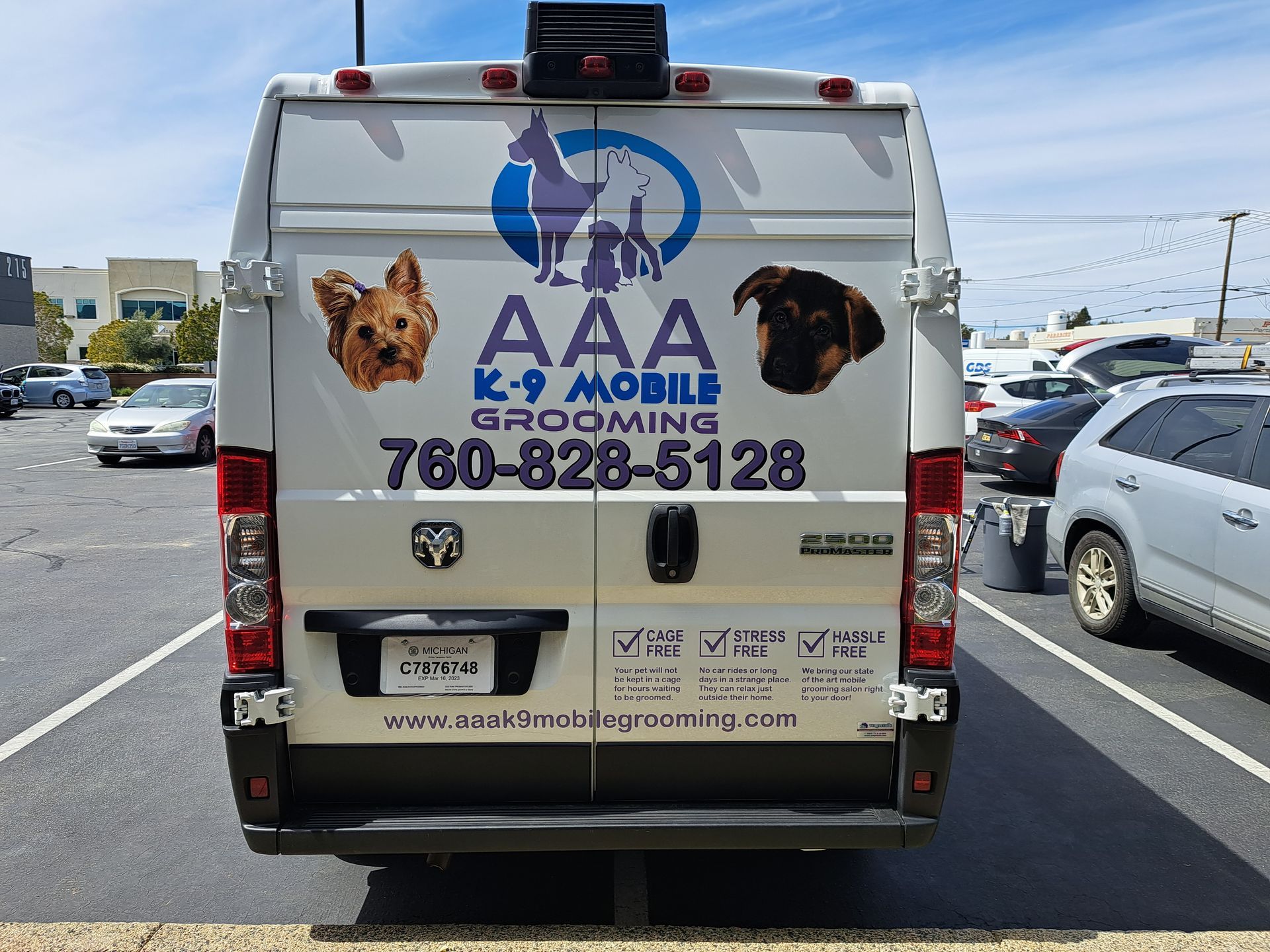 AAA roadside assistance van with phone number and logo parked in traffic, rear view