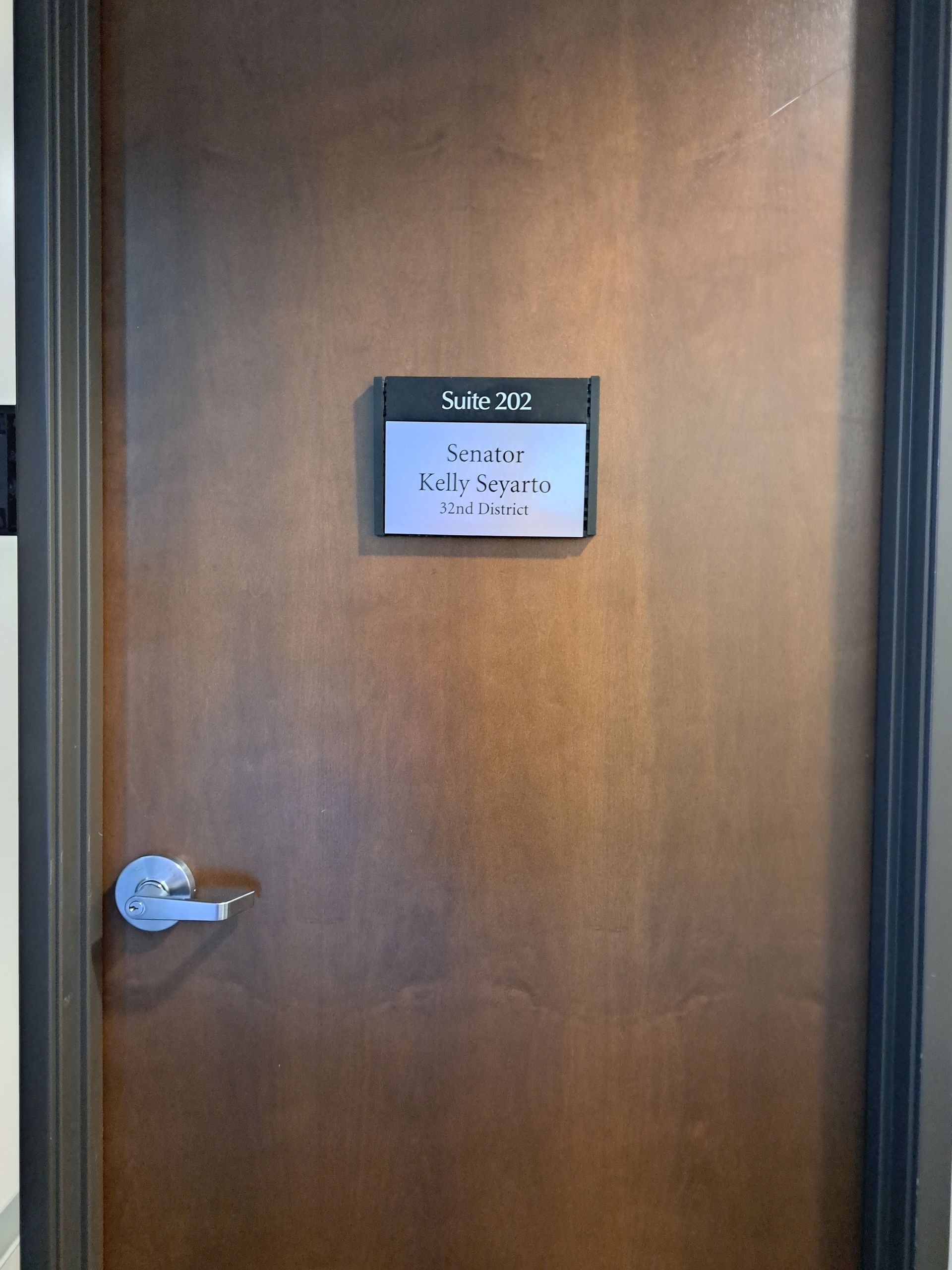 Wooden door with a small wall-mounted display above the handle.