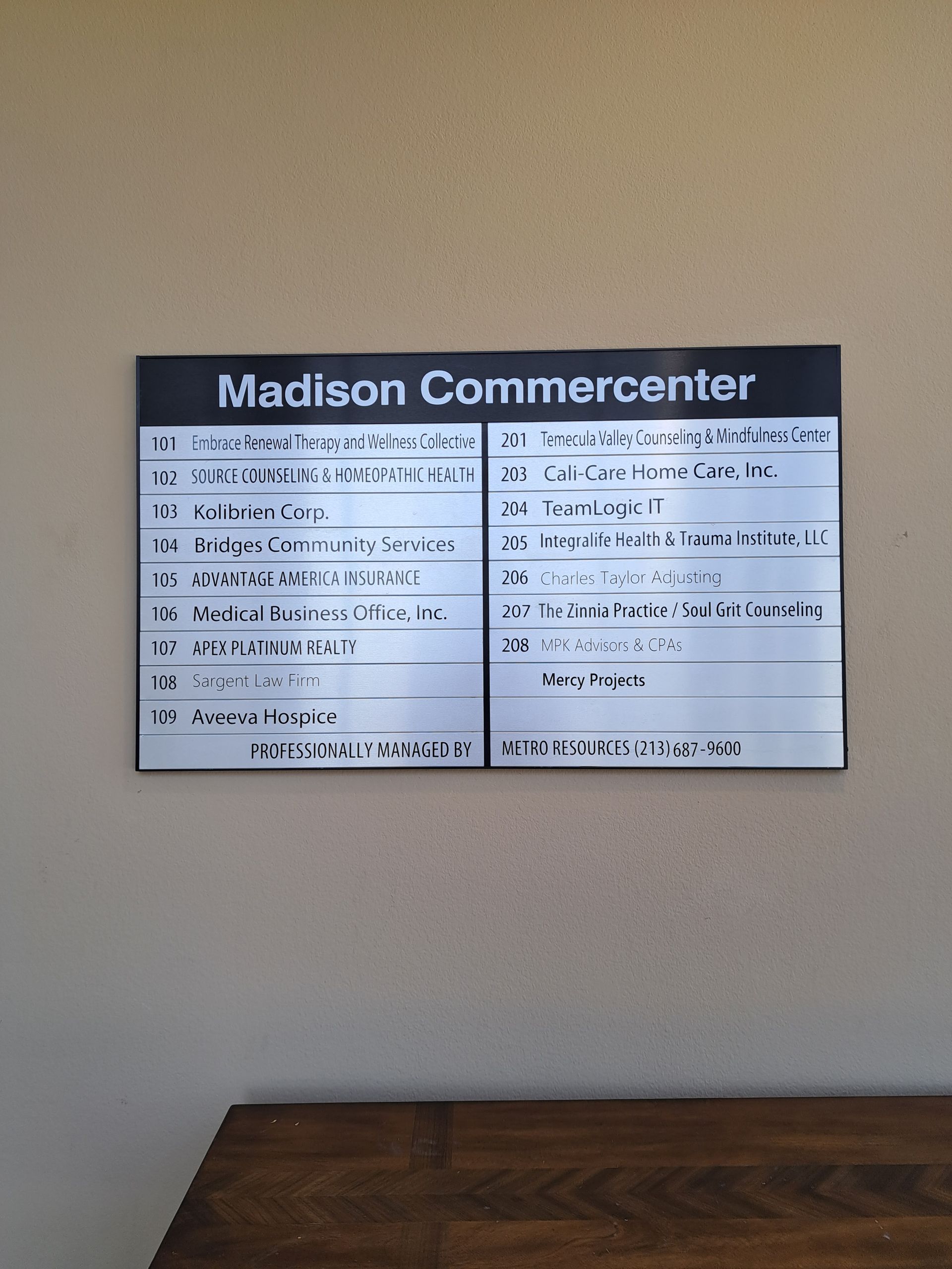 Wall-mounted Madison Community Center schedule board above a wooden table