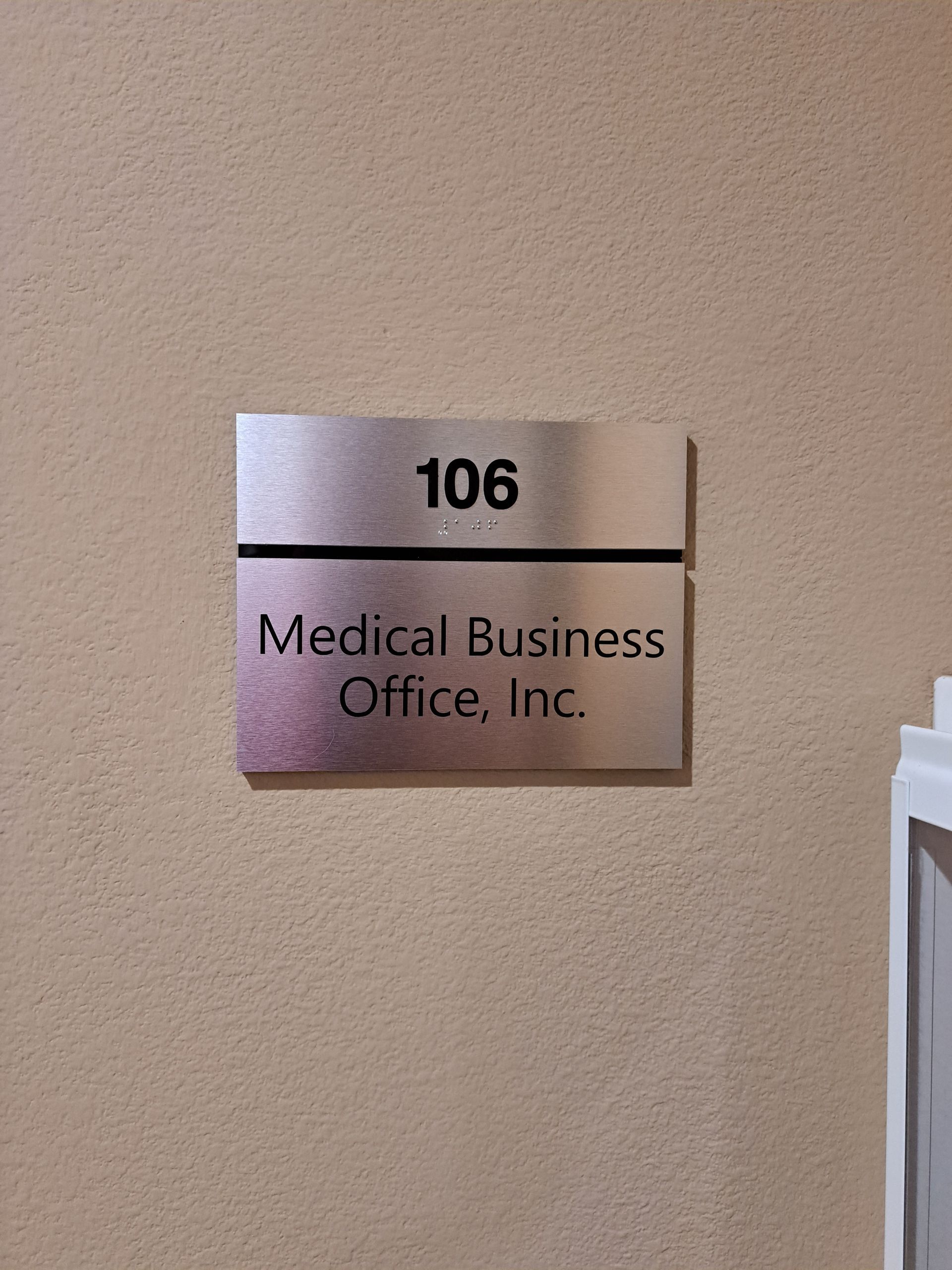 Room 106 sign for Medical Business Office, Inc. on a beige wall