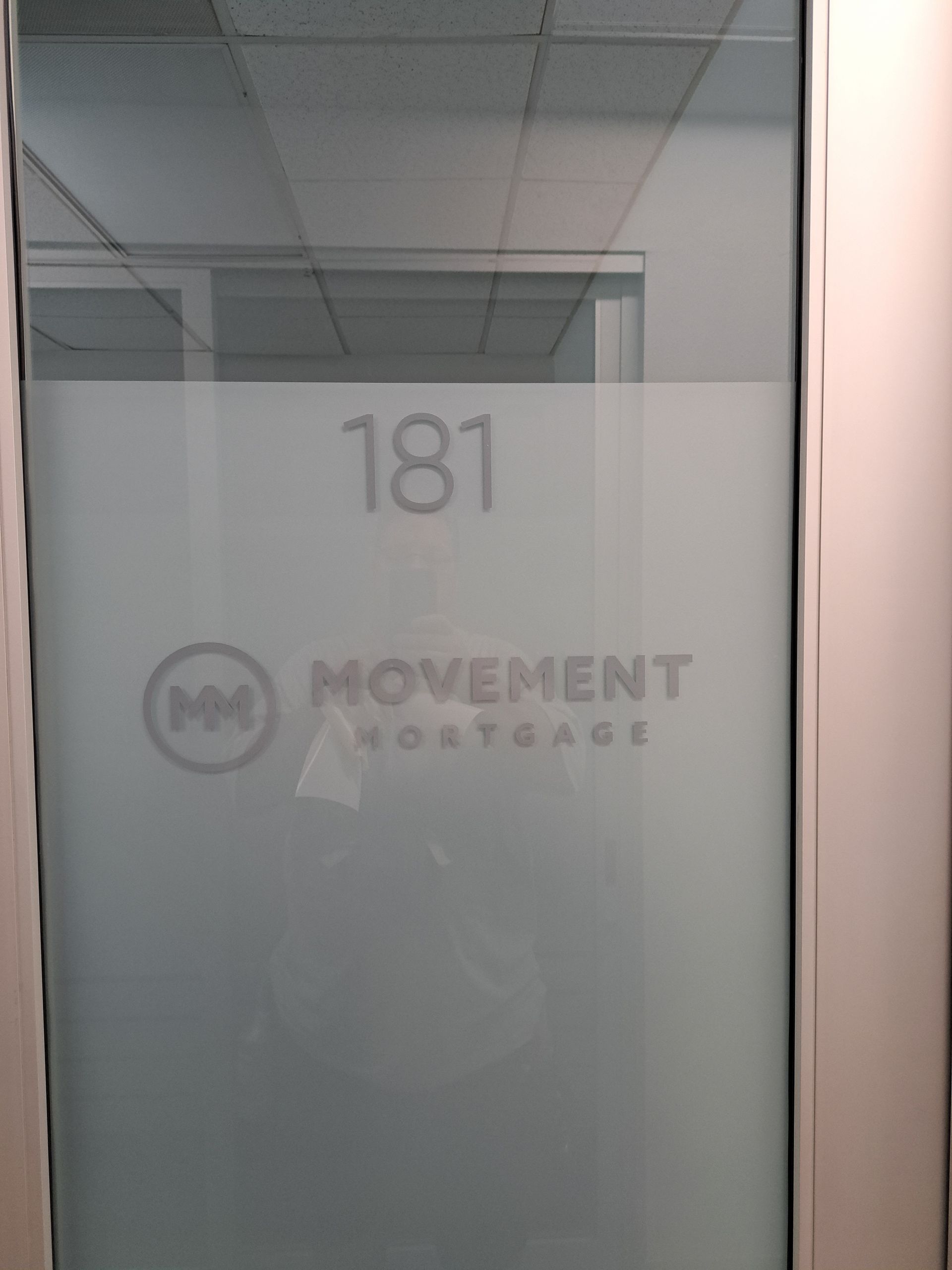Frosted glass office door with room number 181 and Movement Mortgage logo in a hallway