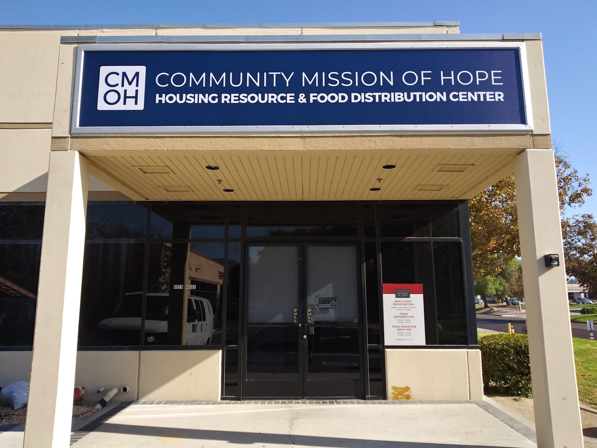 Community Mission of Hope building entrance with blue sign and open storefront