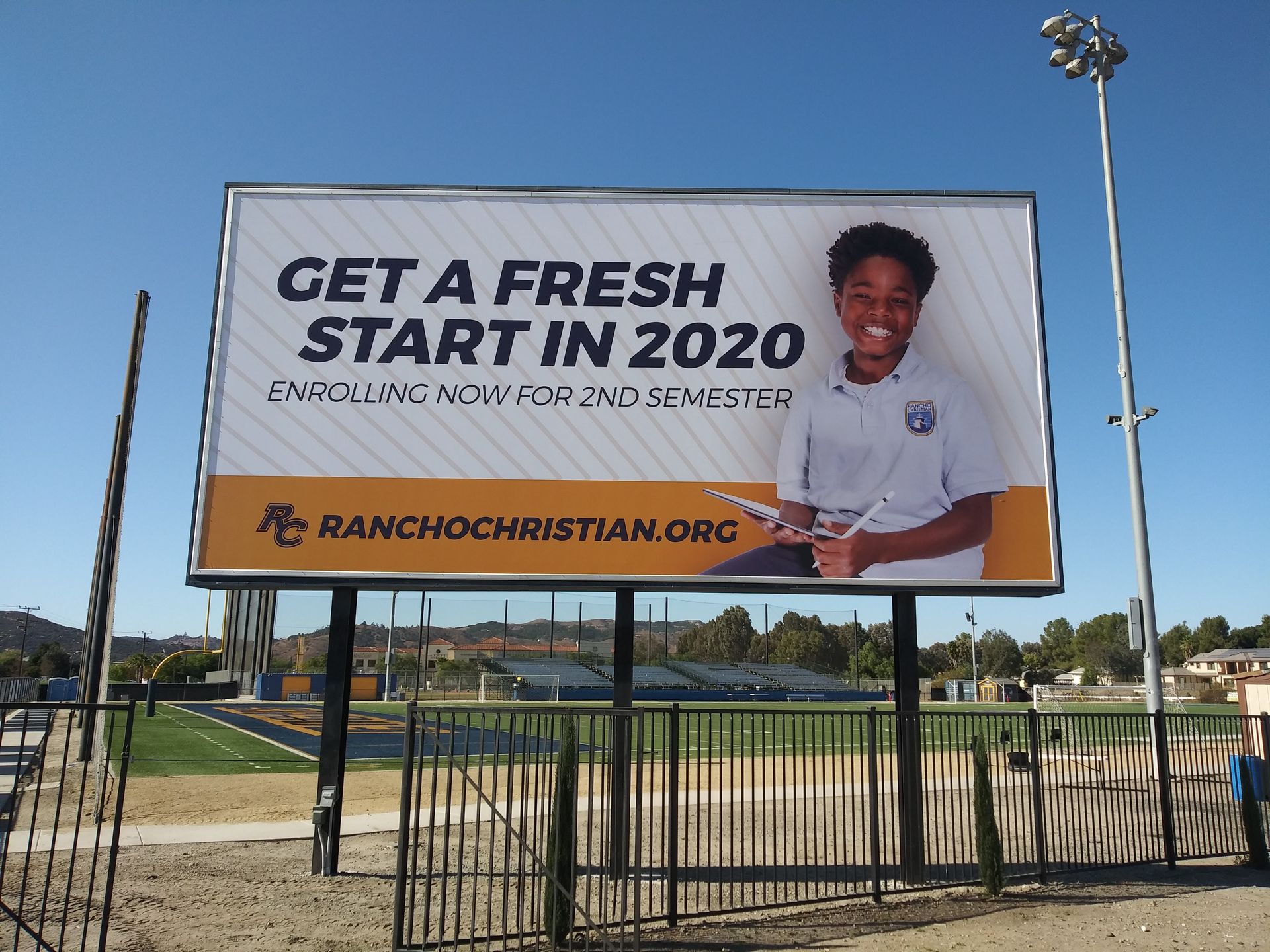 Billboard reads “GET A FRESH START IN 2020,” with a person beside the message and a church website URL.