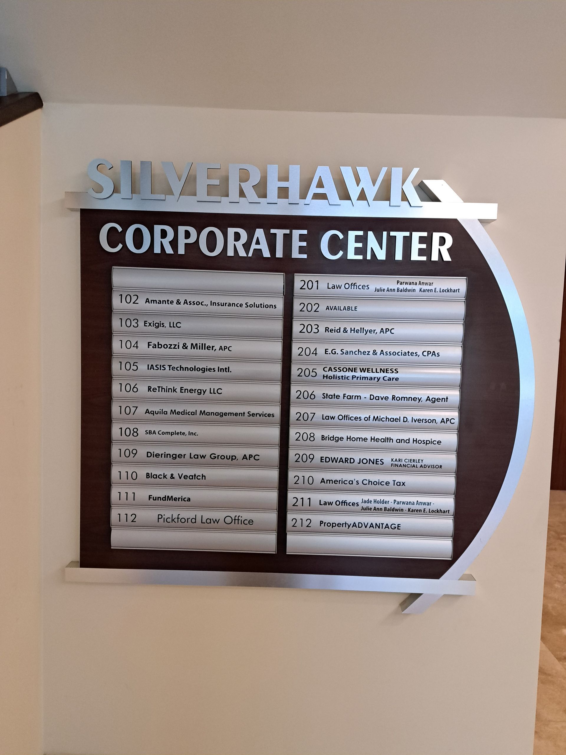 Silverhawk Corporate Center directory sign with tenant names on a beige wall.