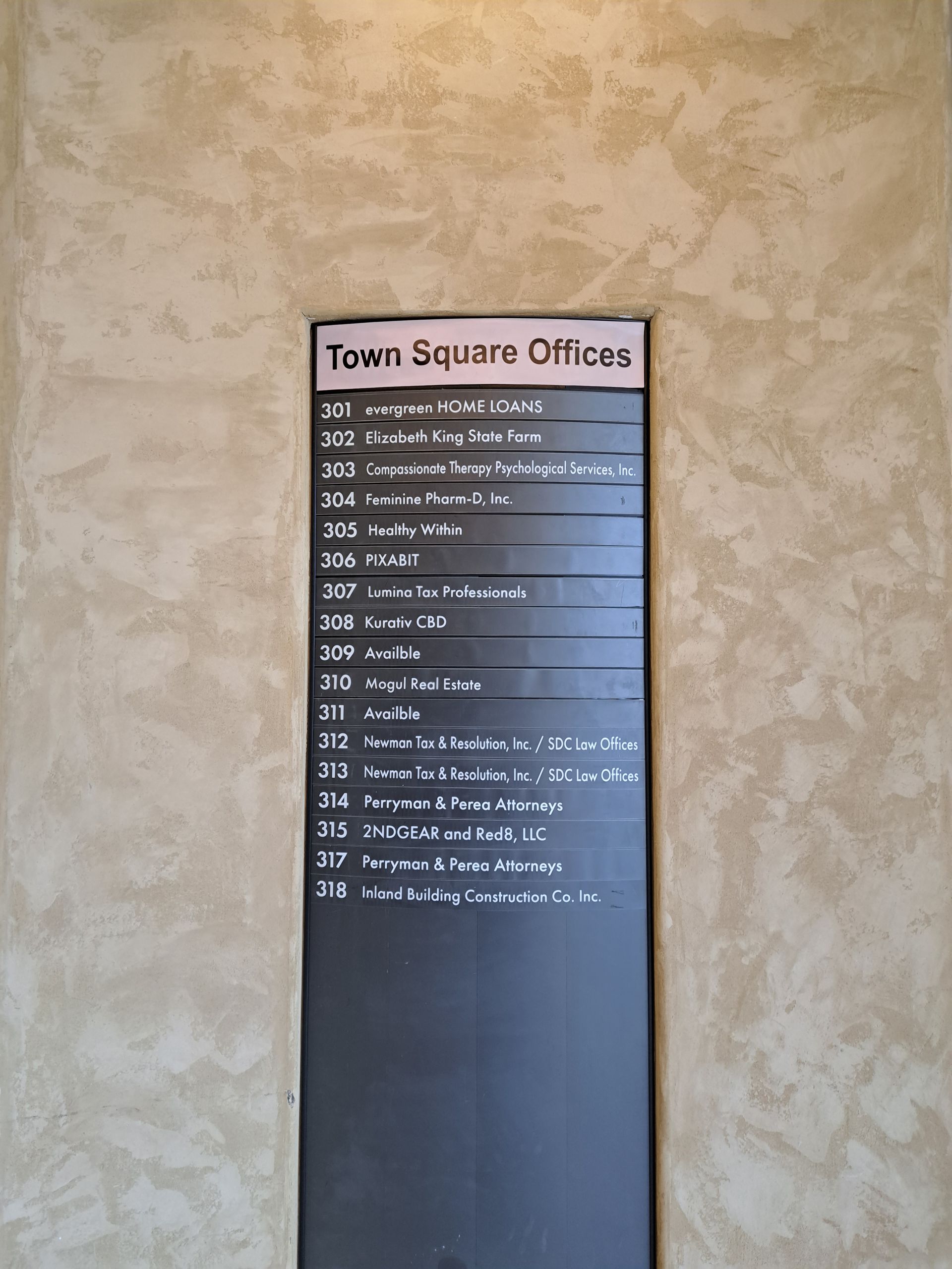 Town Square Offices directory on a beige textured wall, with white text on a dark panel.