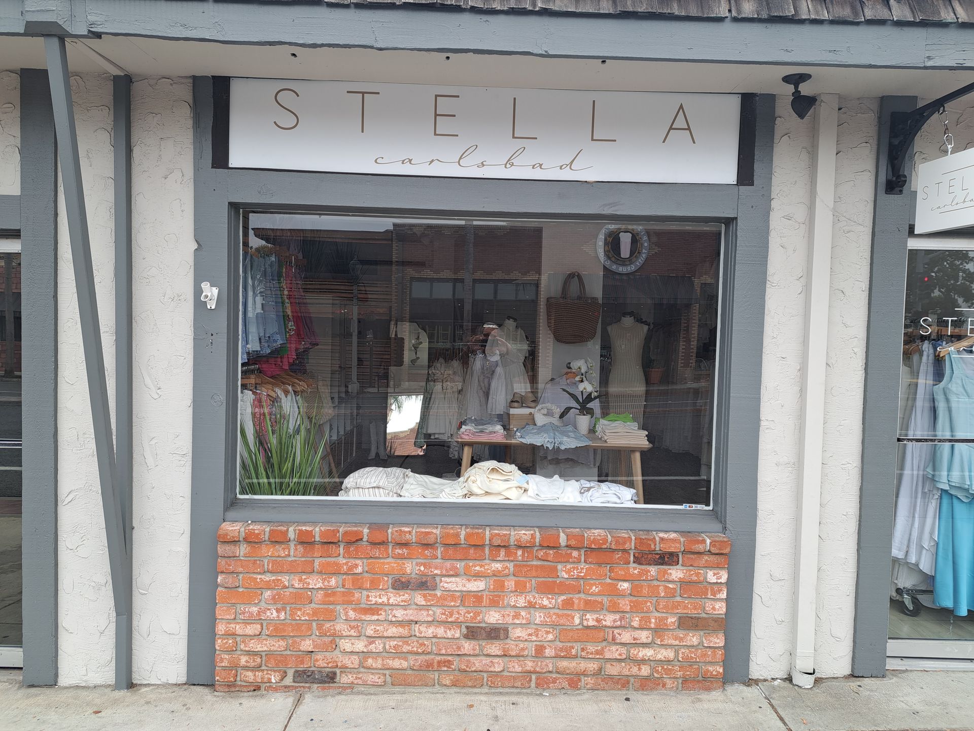 Storefront with a large display window, brick base, and a sign reading “STELLA” above the entrance.