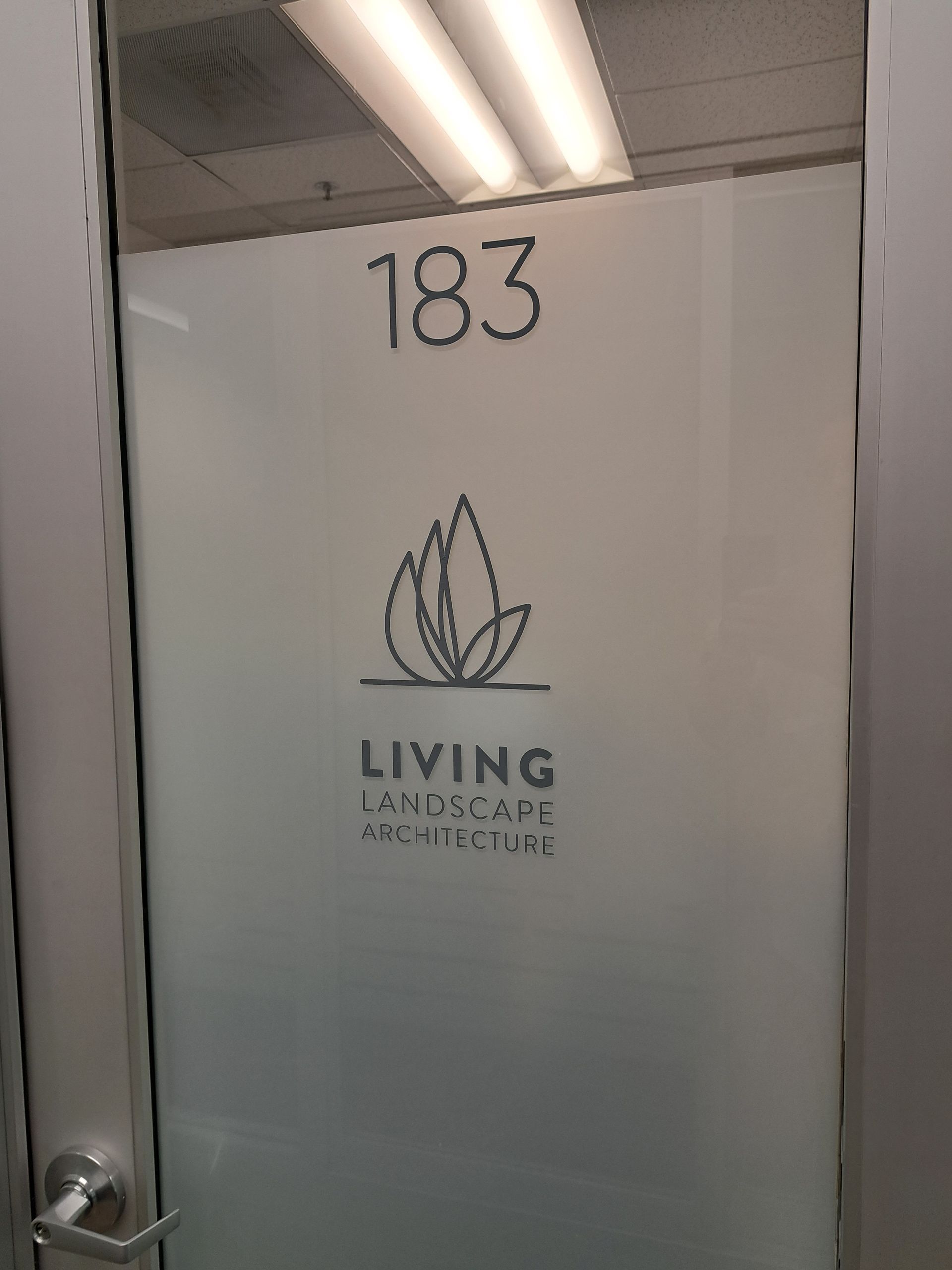 Door labeled “183” with a Living Homes sign and logo in a hallway