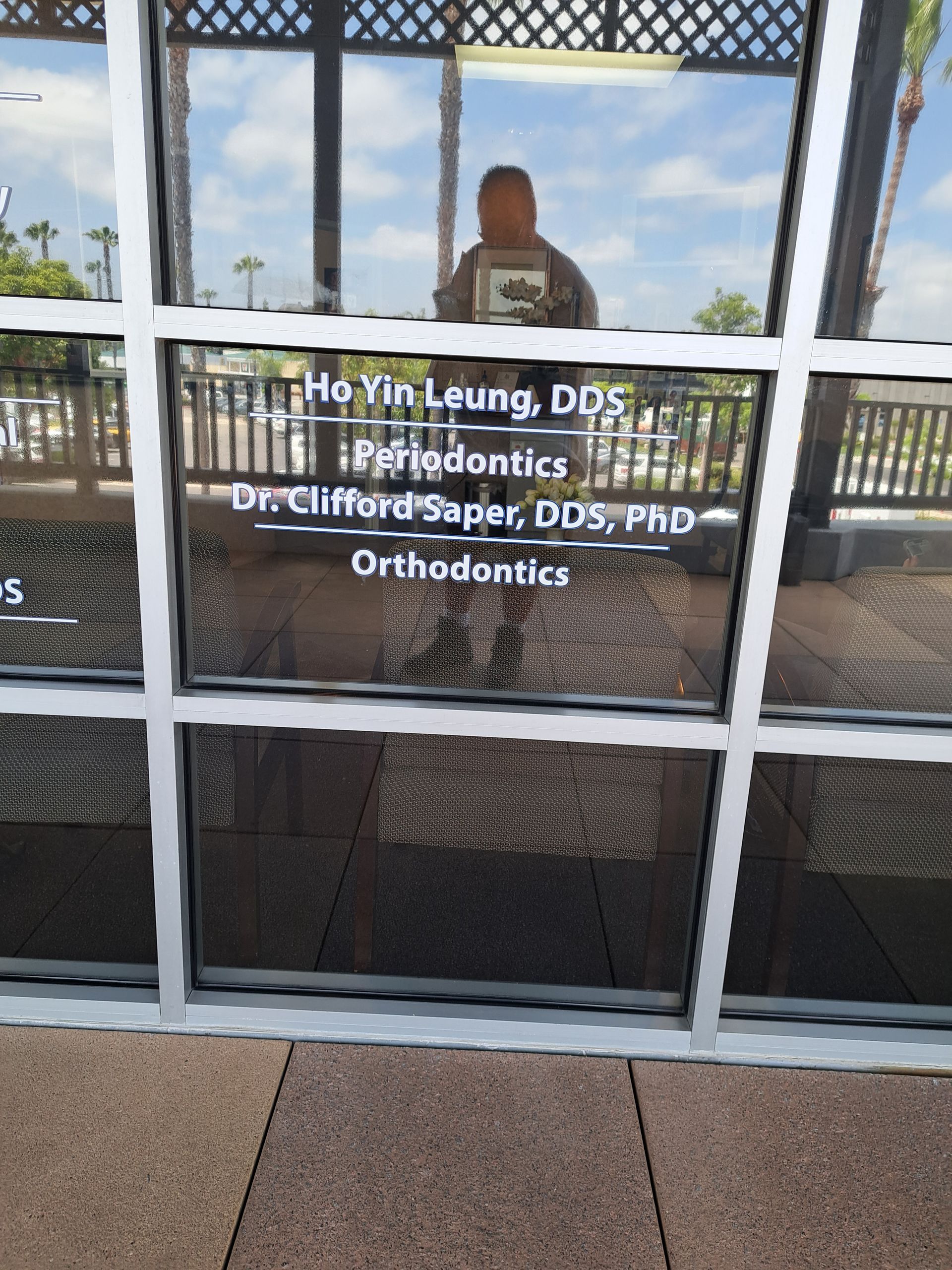 Glass door entrance to an orthodontics office with doctor names and reflections visible