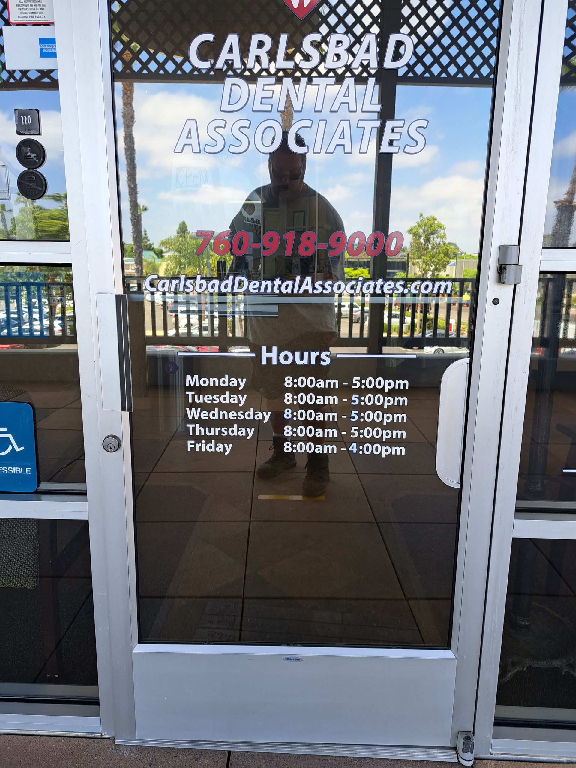 Glass storefront door for Carlsbad Behavioral Associates with business hours and contact info displayed.