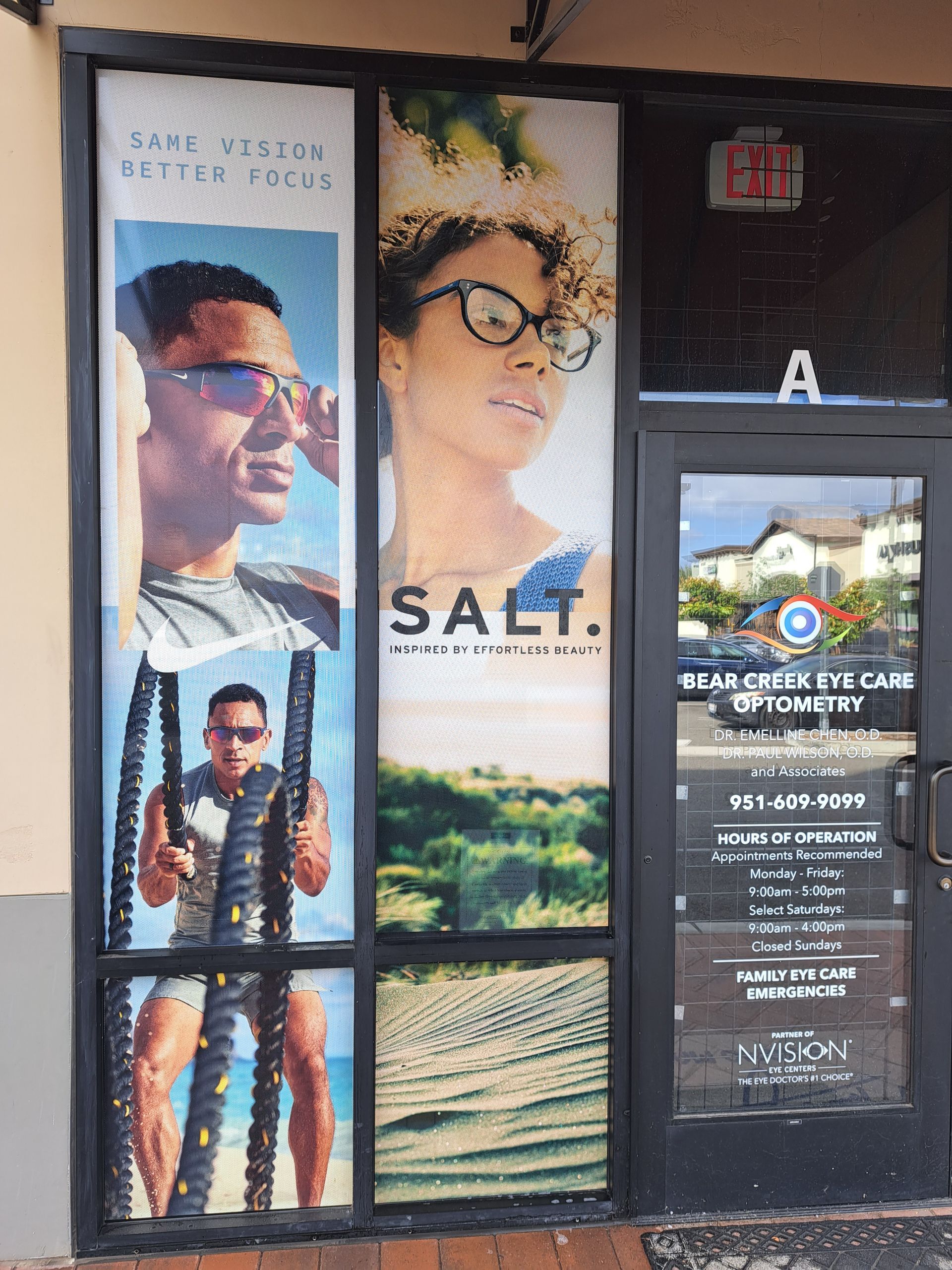 Storefront posters and a vertical sign for “SALT,” featuring portraits and a seaside landscape