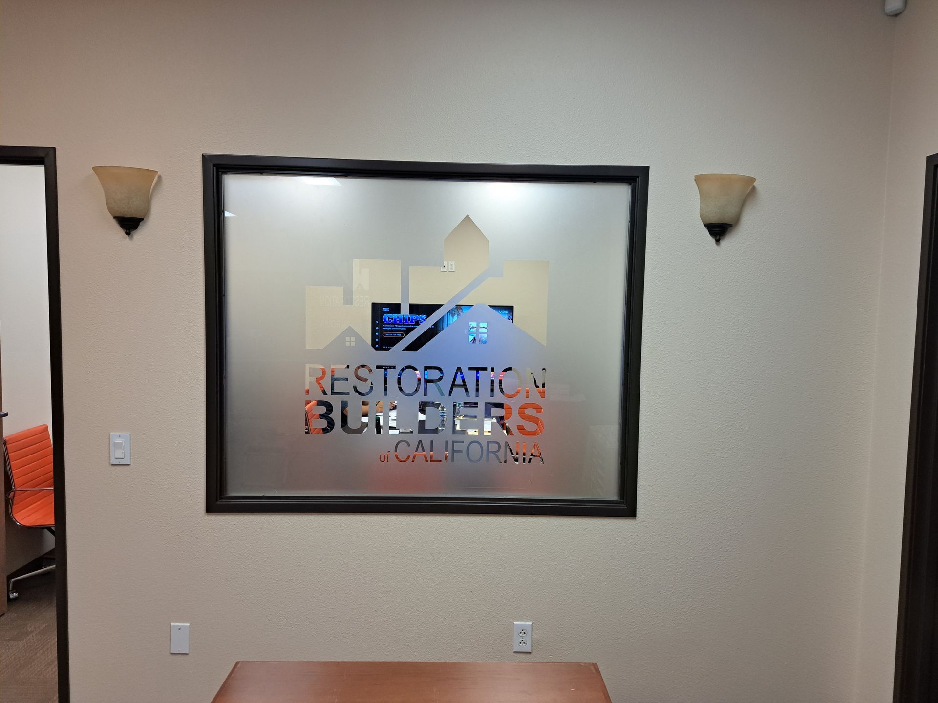 Wall sign reading “Restoration Browsers” in a beige office lobby with wall sconces