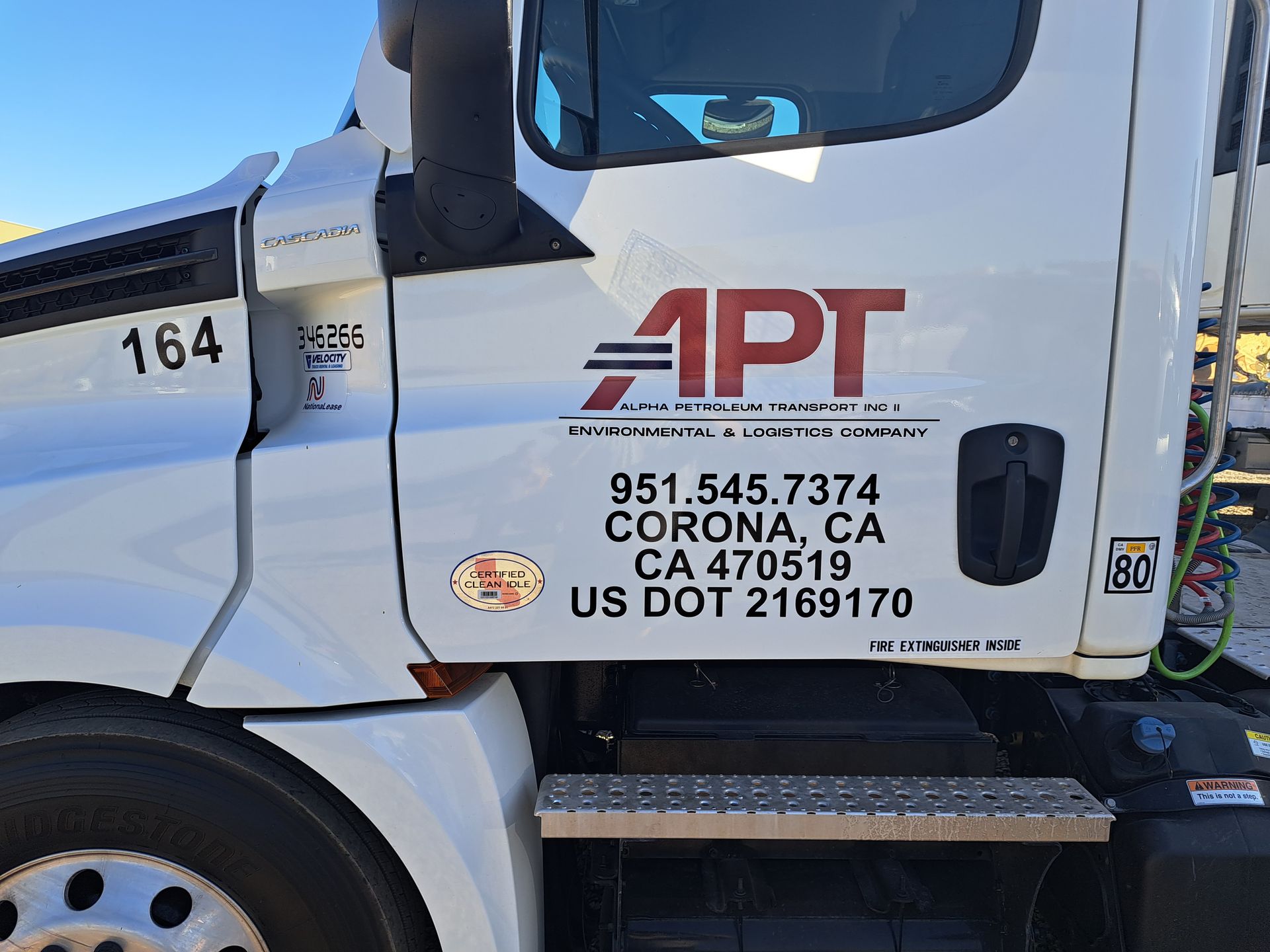 White APT truck cab with company logo and phone number parked outdoors