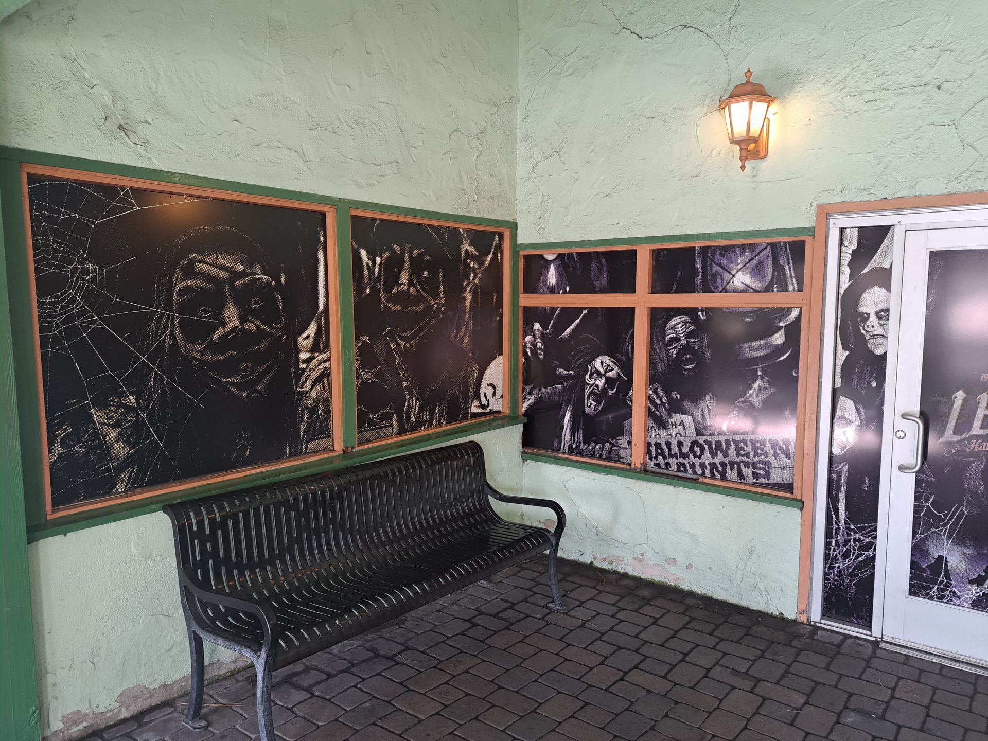 Blackboard wall with a bench in a mint-green hallway, beside a window and door with frosted glass