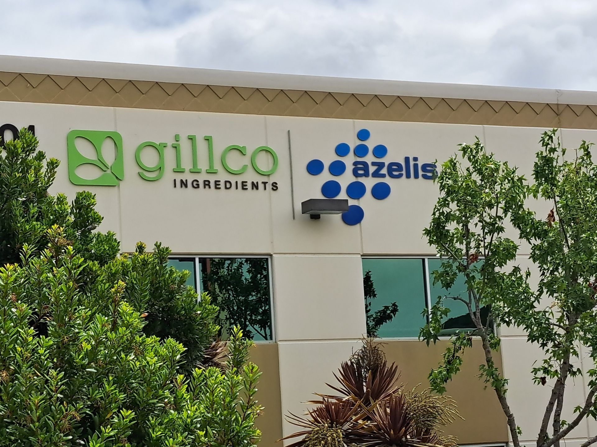 Gillco Ingredients and Azelis signs on an office building with trees in front