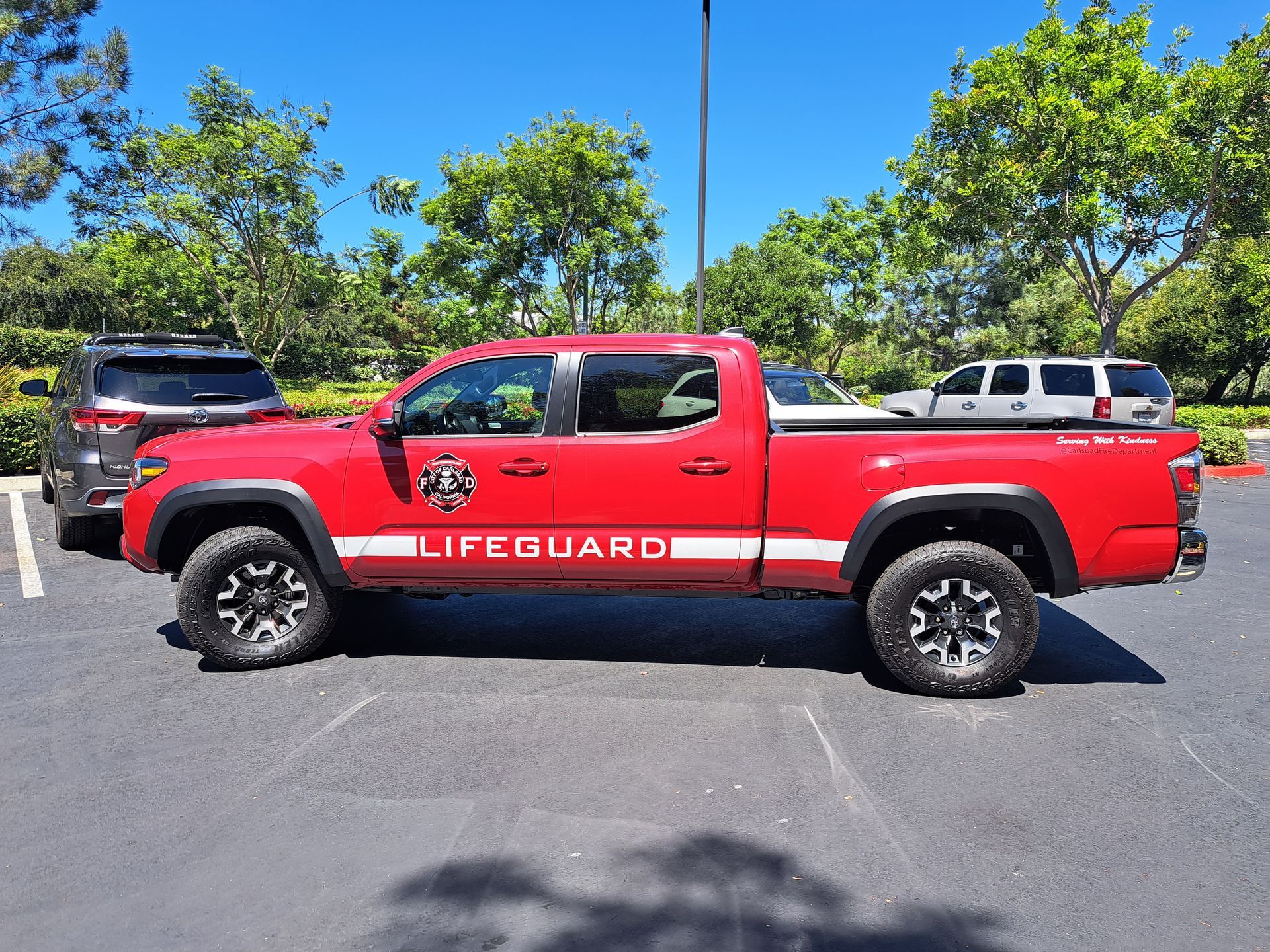 Red lifeguard pickup truck parked in a lot on a sunny day