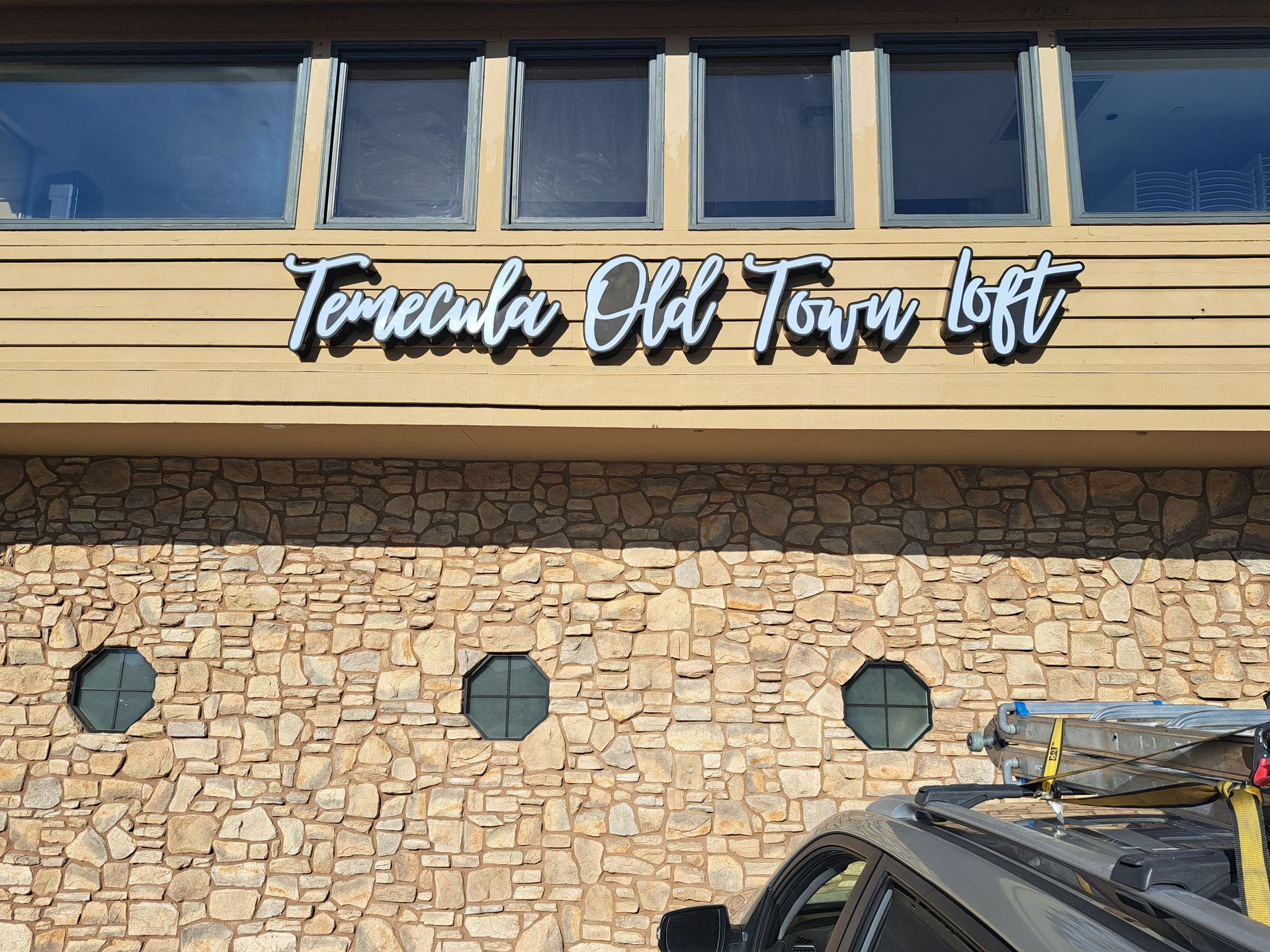 Tenerife Old Town loft sign on a stone building facade with windows above