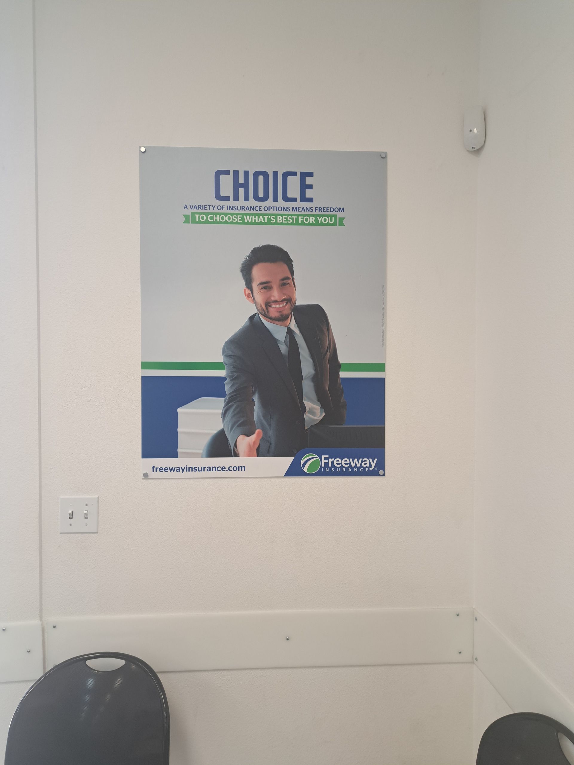 Poster on a wall with a smiling man in a suit and the word “CHOICE” at the top.