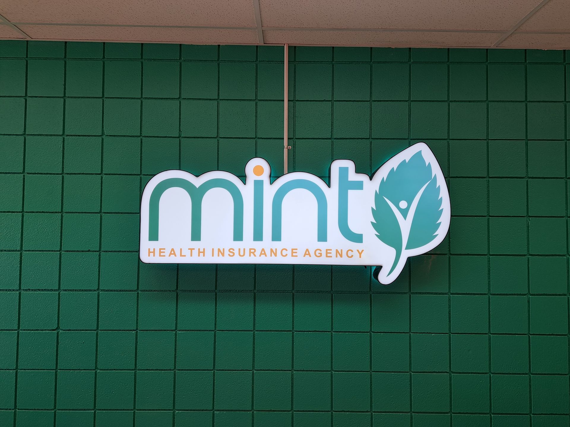 Mint Health Insurance Agency logo on a green wall sign