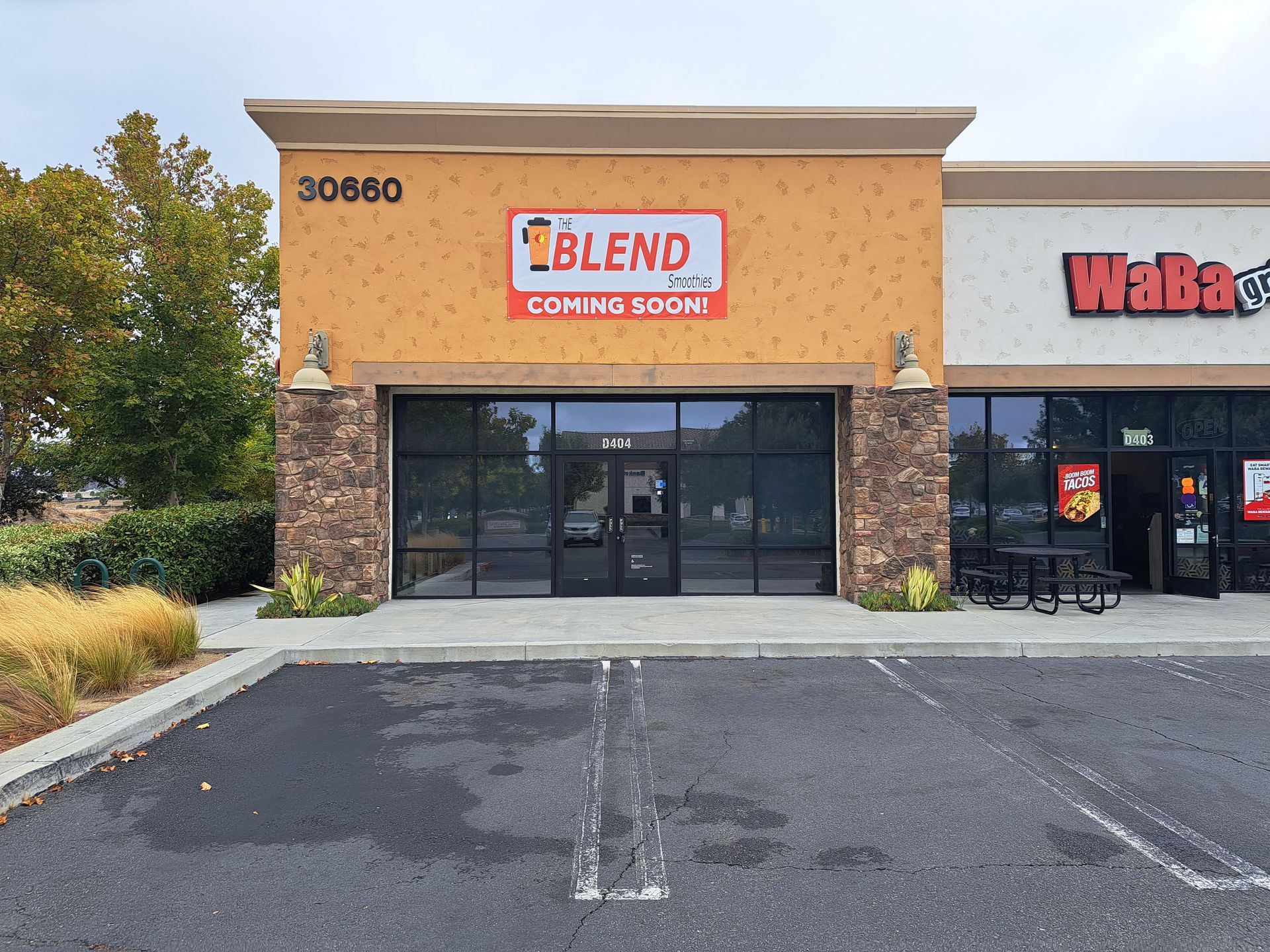 Storefront with “BLEND” coming soon sign, tan facade, and empty parking lot