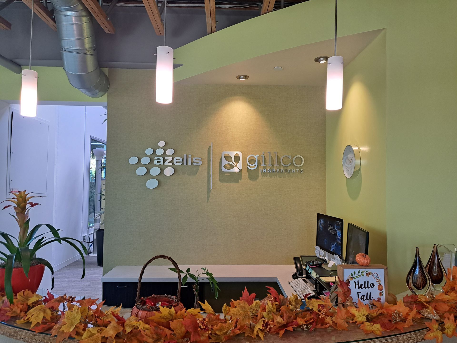Lobby reception desk with orange autumn decor and wall logos behind it