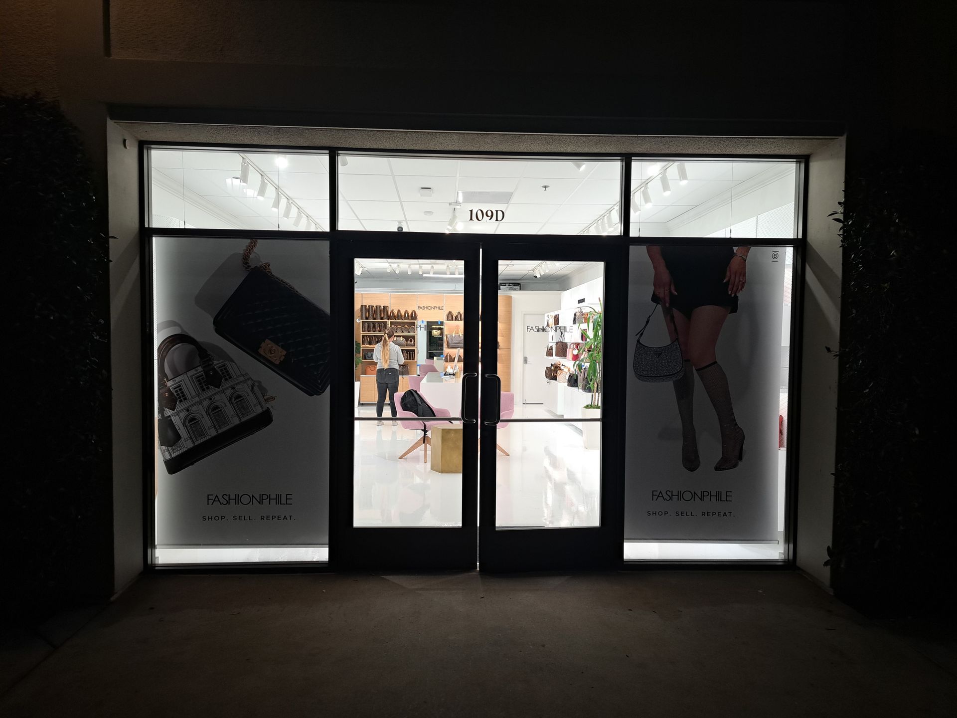 Mall storefront entrance with glass doors, bright interior, and fashion posters on the windows