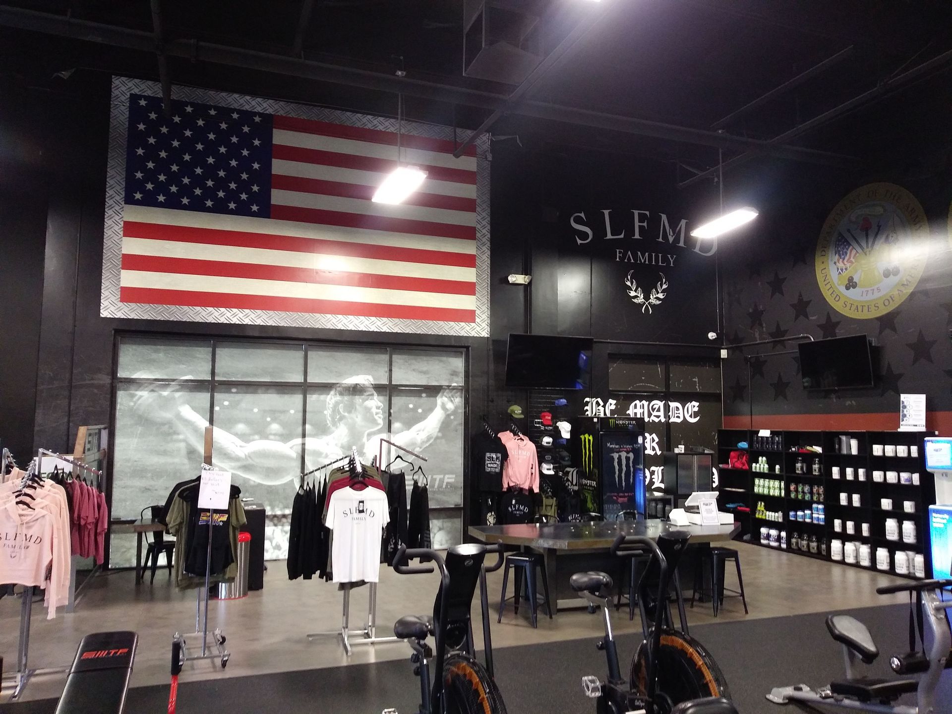 Retail store interior with large American flag, clothing racks, and wall-mounted displays