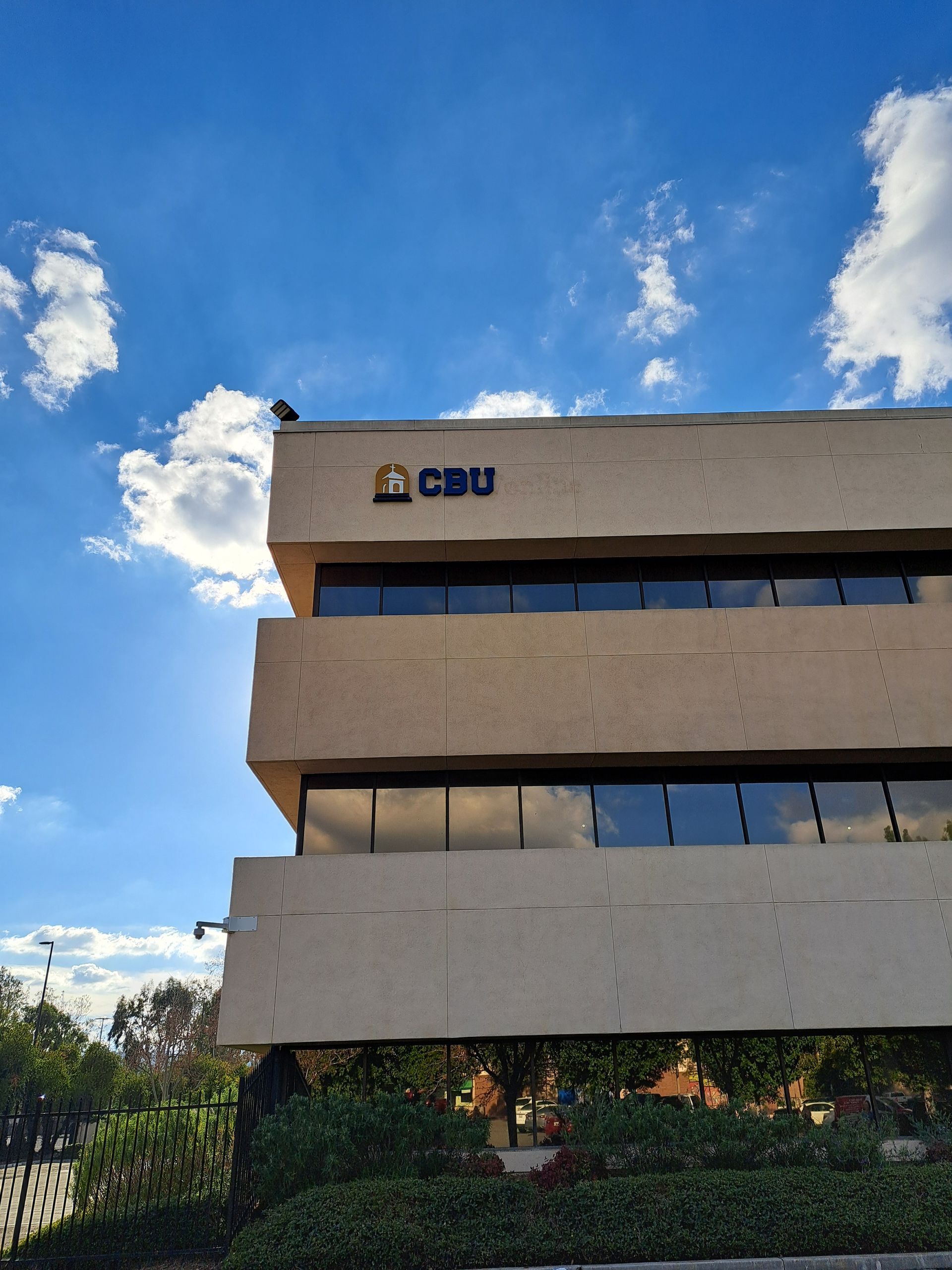 Modern office building under a bright blue sky with clouds