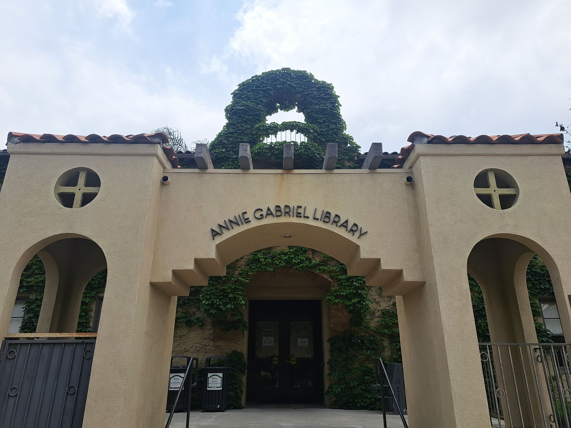 Entrance of Annie Gabriel Library with arched doorway and ivy-covered facade