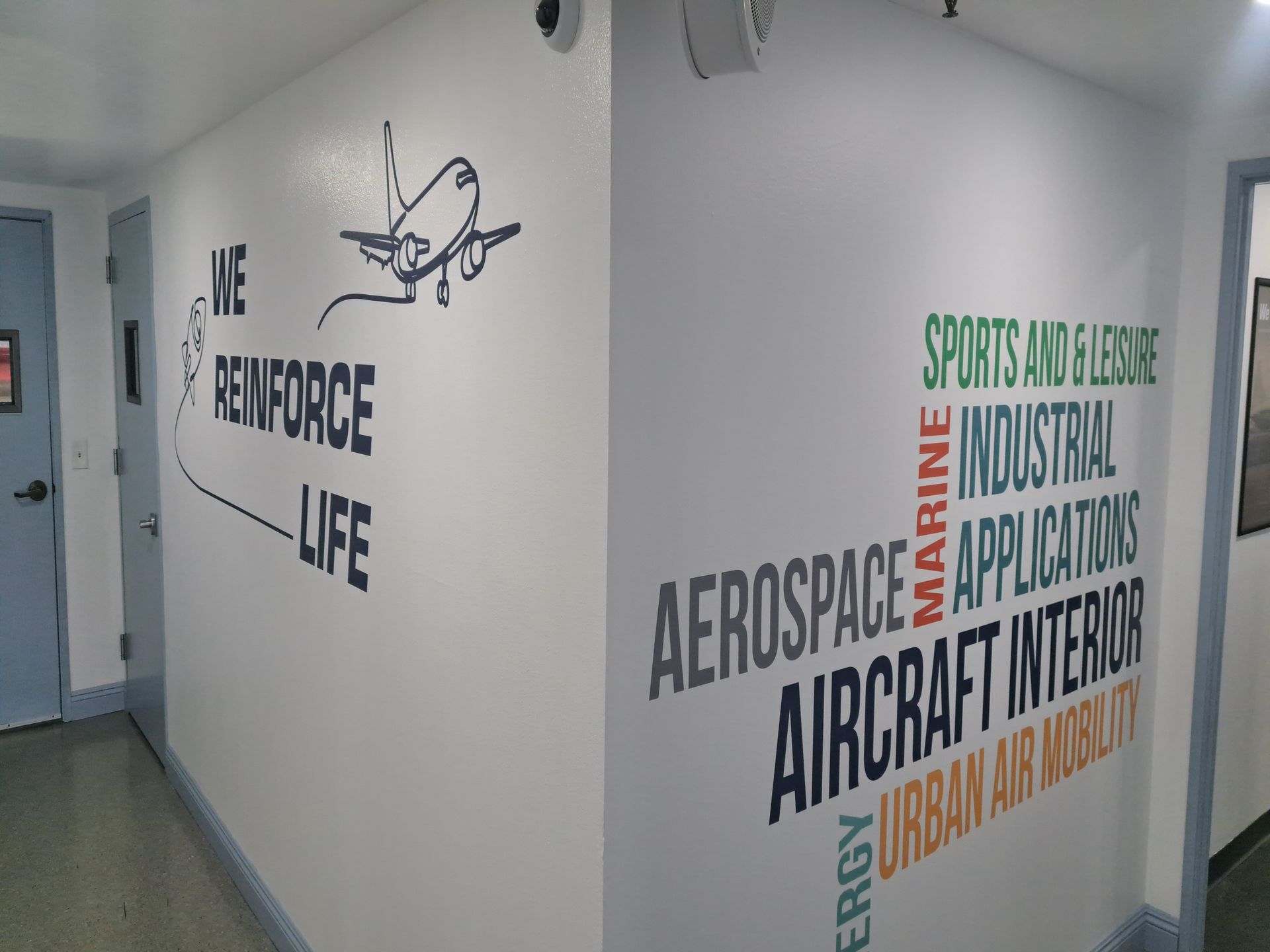 Hallway wall with aerospace-themed words and a bird logo in black, green, and orange.