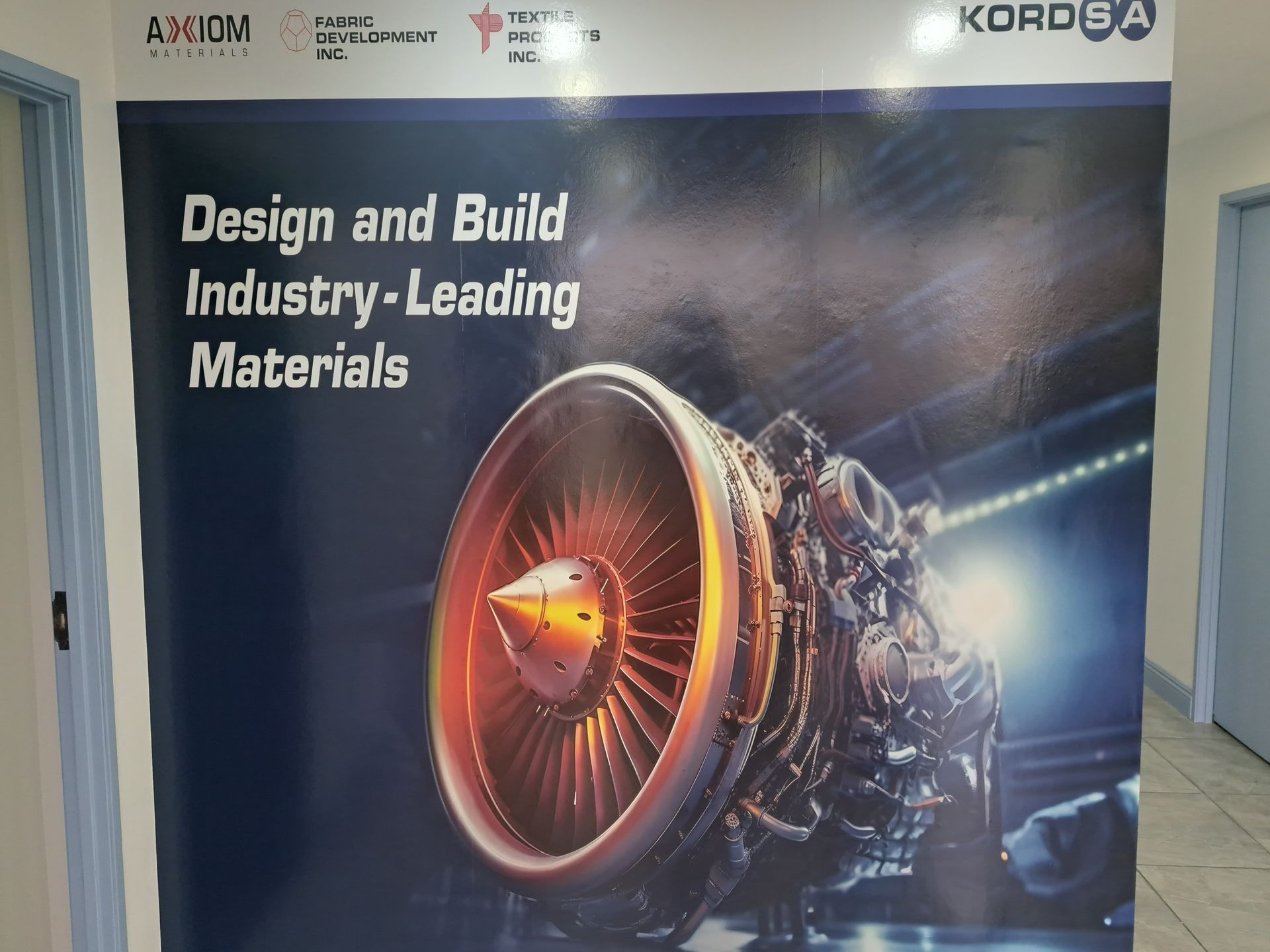 Promotional poster with jet engine and the text “Design and Build Industry-Leading Materials”