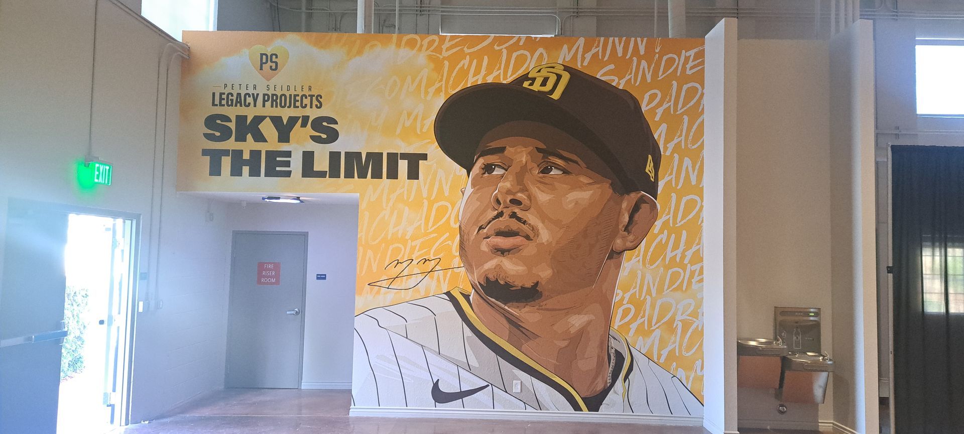 Mural of a baseball player with the words “SKY’S THE LIMIT” in an indoor hallway