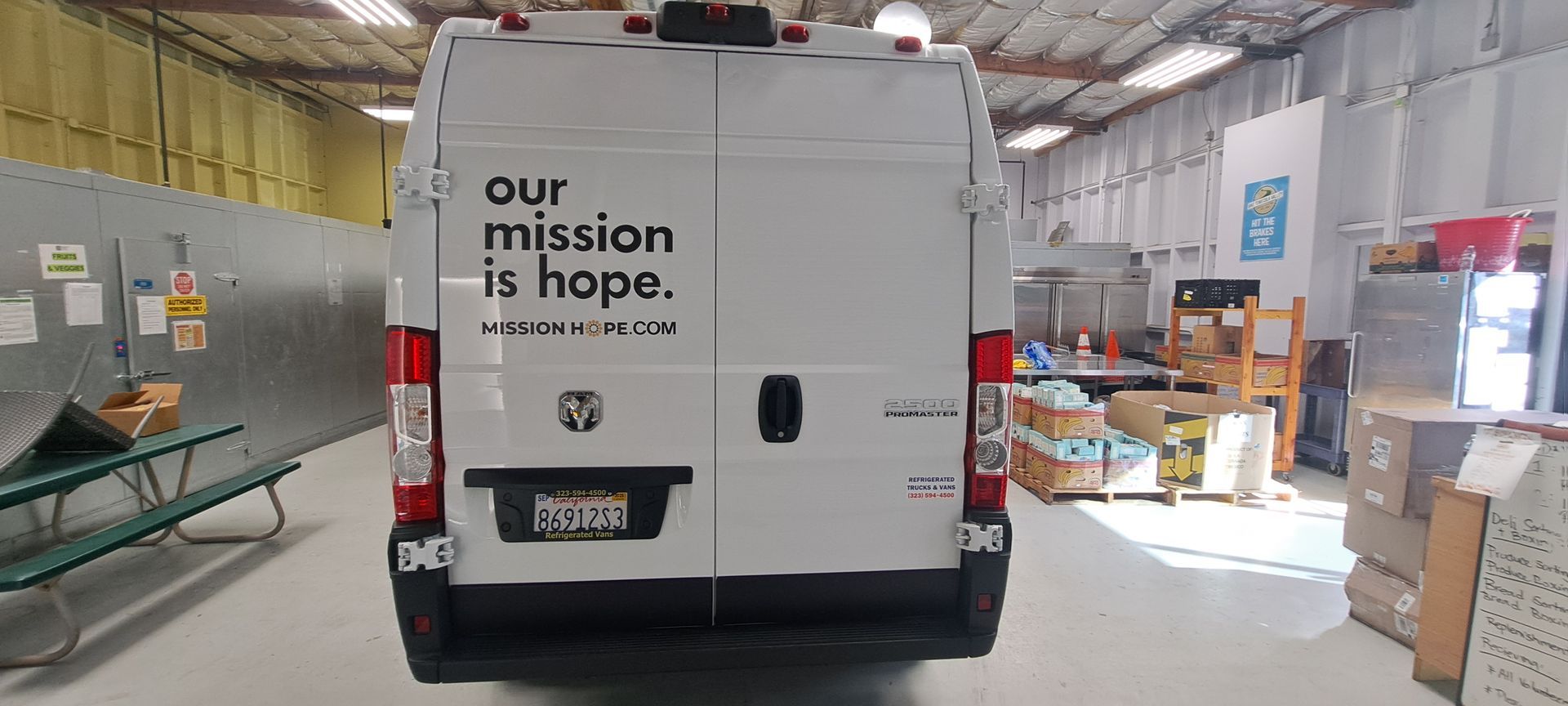 White van inside a warehouse, with “our mission is hope.” printed on the back door.