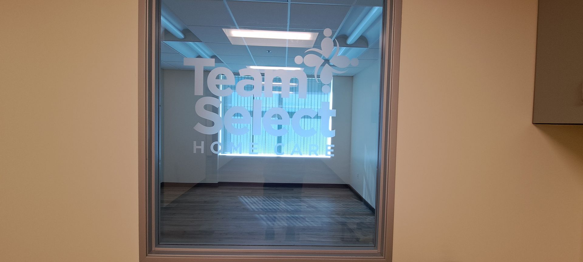 Glass window view into a hallway with large “Team Swift” text on the wall