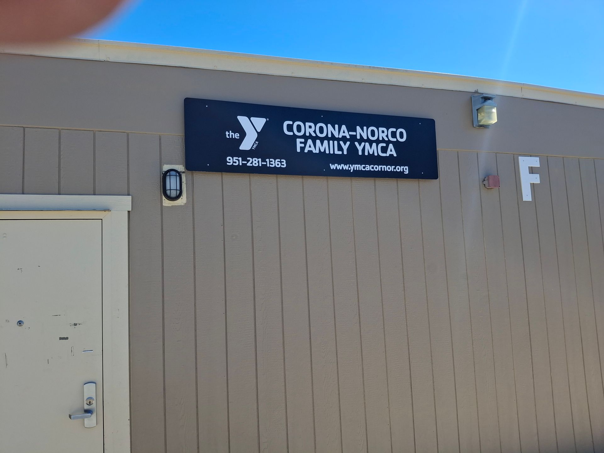 Corona-Norco Family YMCA sign on a beige building exterior