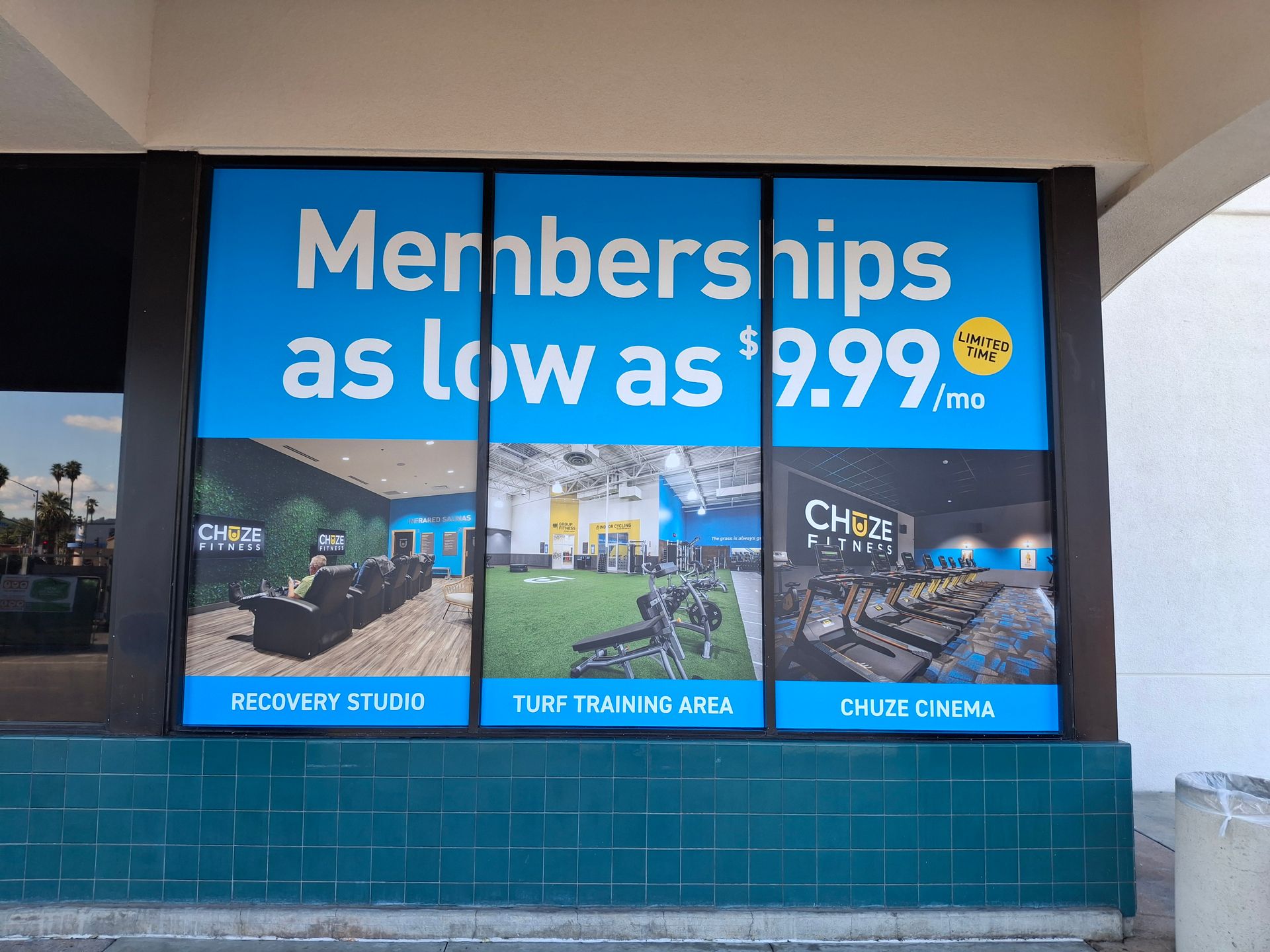 Store window sign advertising memberships as low as $9.99/week in blue and white.