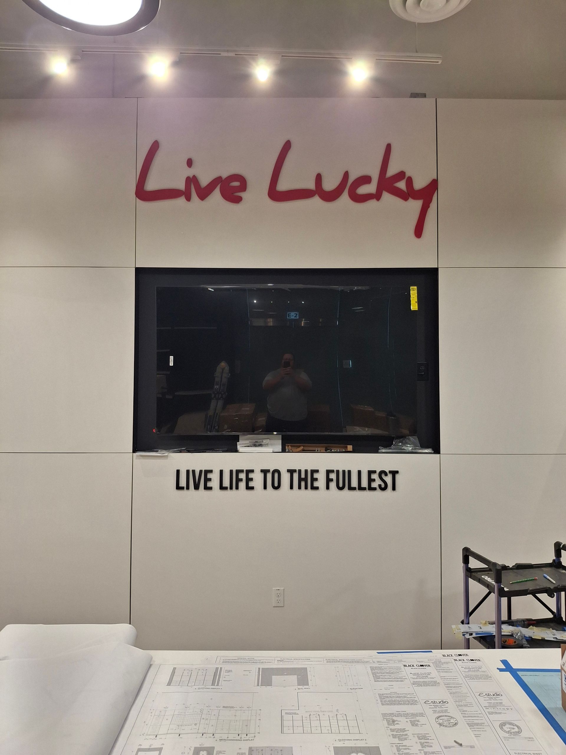 “Live Lucky” sign above a wall display with “Live Life to the Fullest” text in a bright lobby