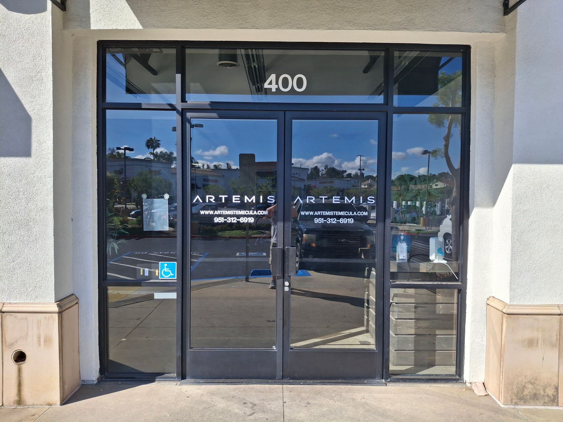Glass entrance doors at 400 with ARTEMIS signage on a storefront building