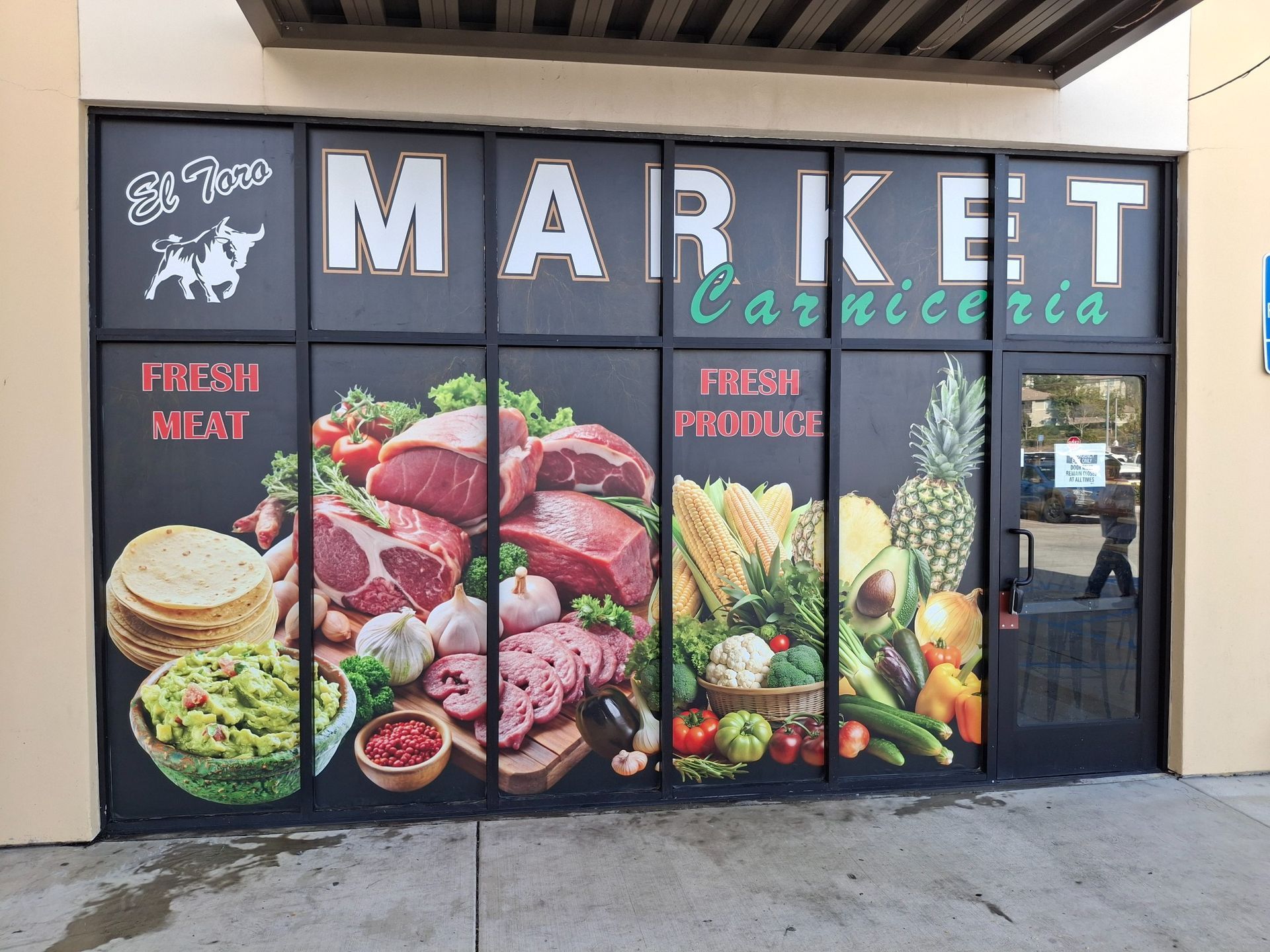 Storefront of Market Carniceria with large meat and produce window graphics