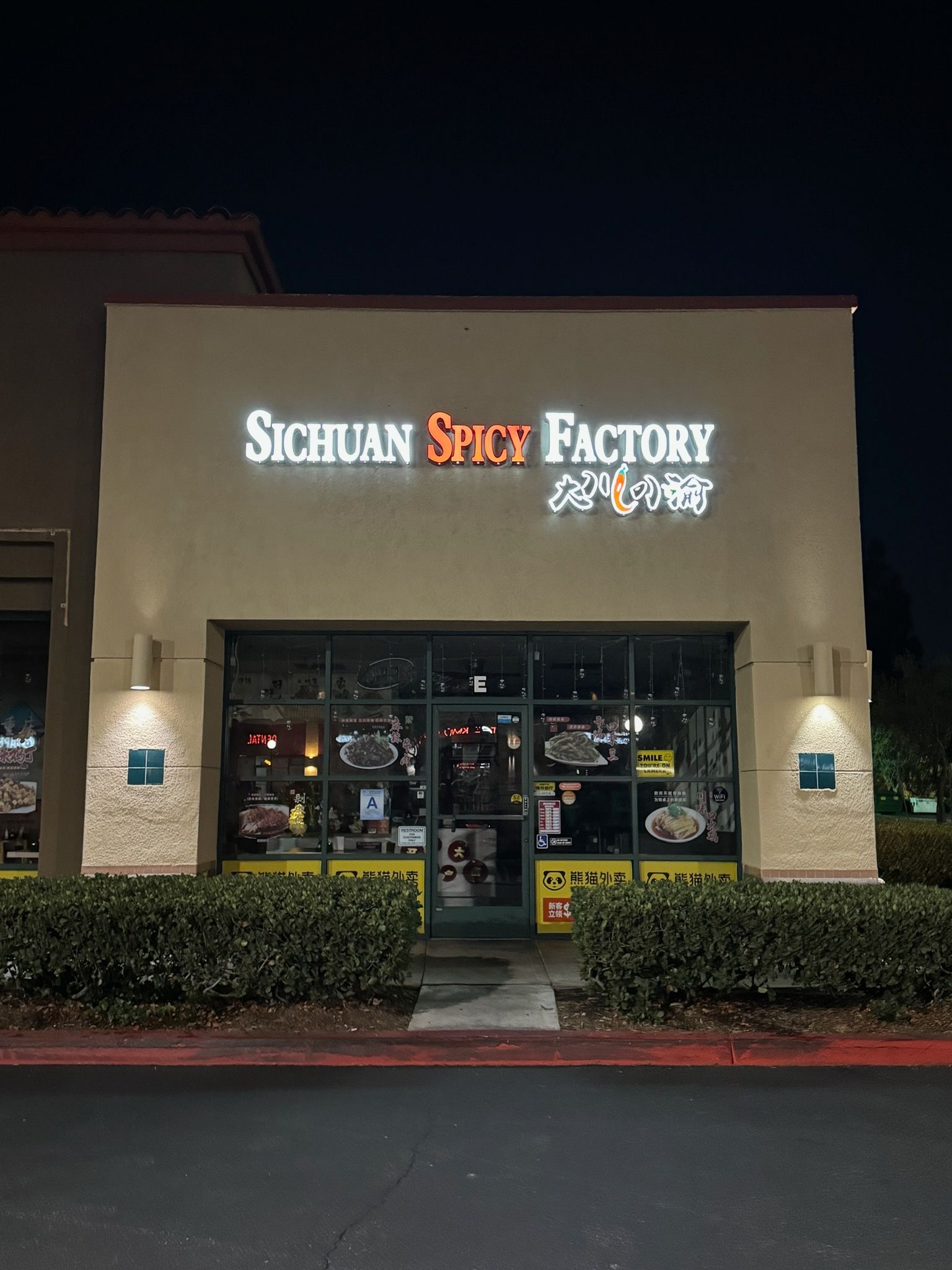 Nighttime exterior of Sichuan Spice Factory restaurant with lit sign and front windows