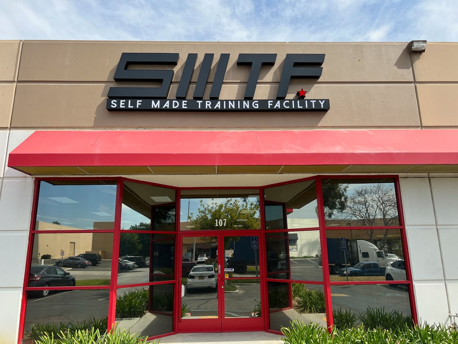 S.M.T.F. self made training facility storefront with red awning and glass entrance